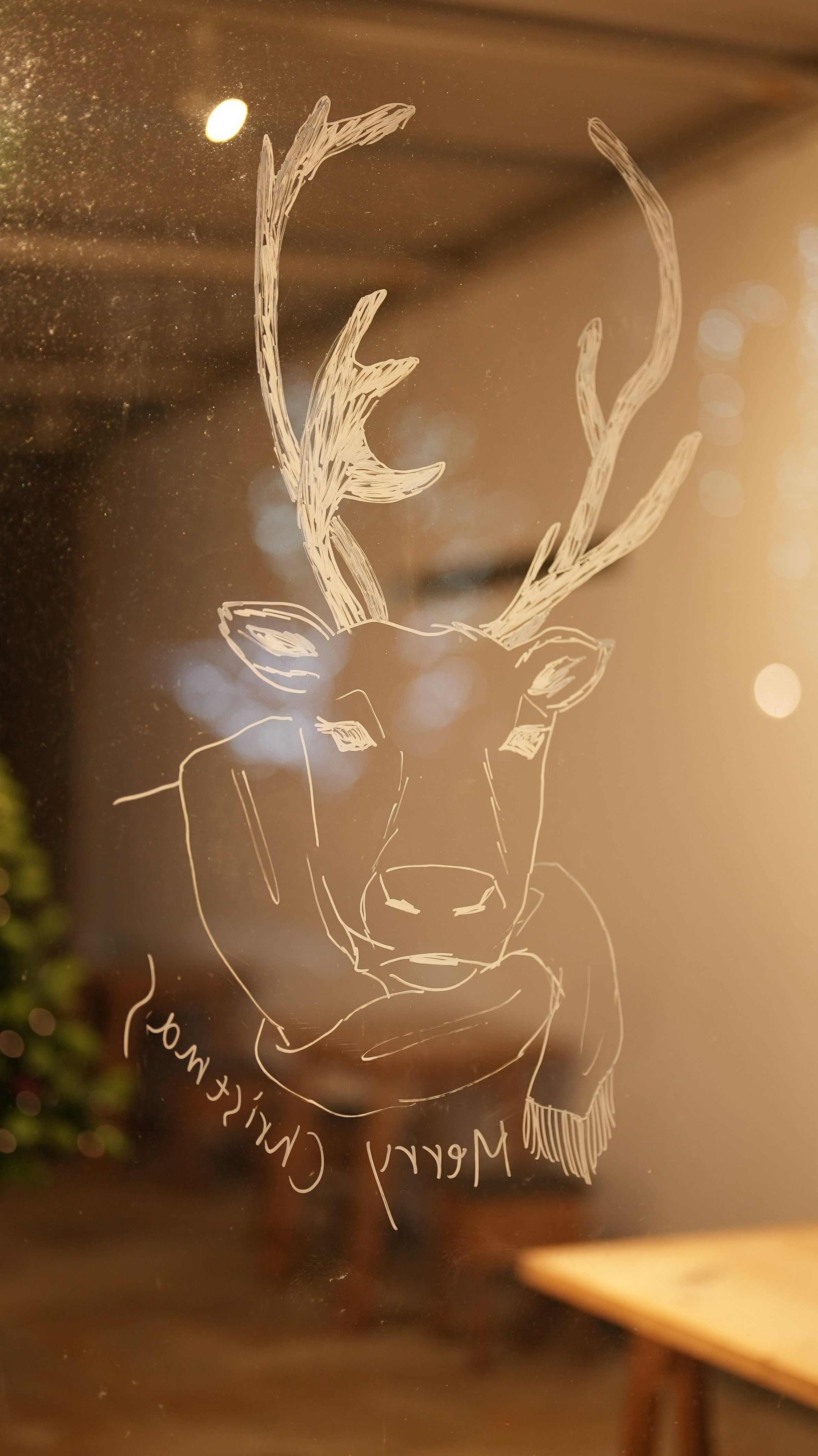 dessin au trait d’un renne sur verre avec flou lumineux