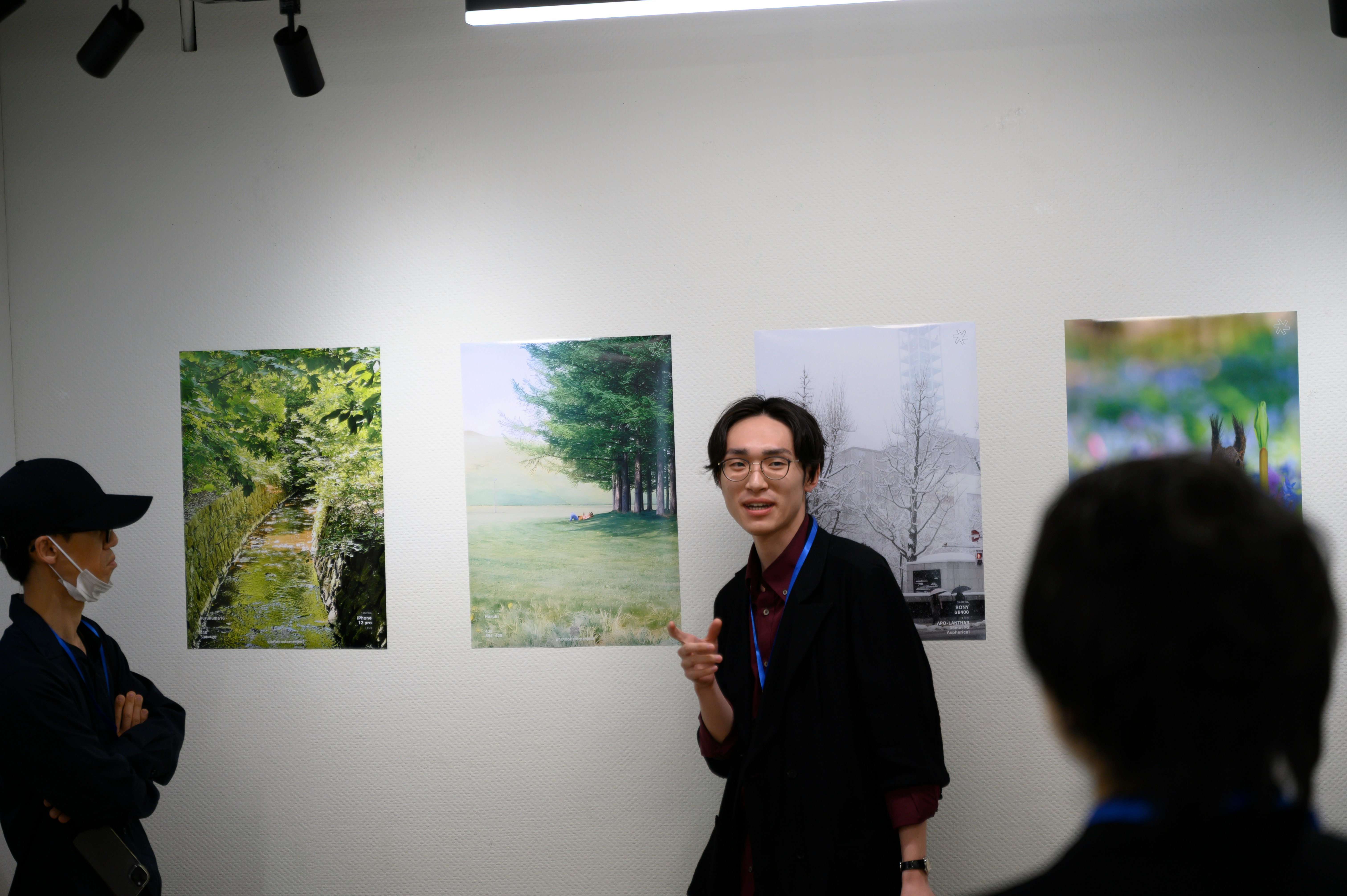 gallery wall with a person presenting paintings at an exhibition