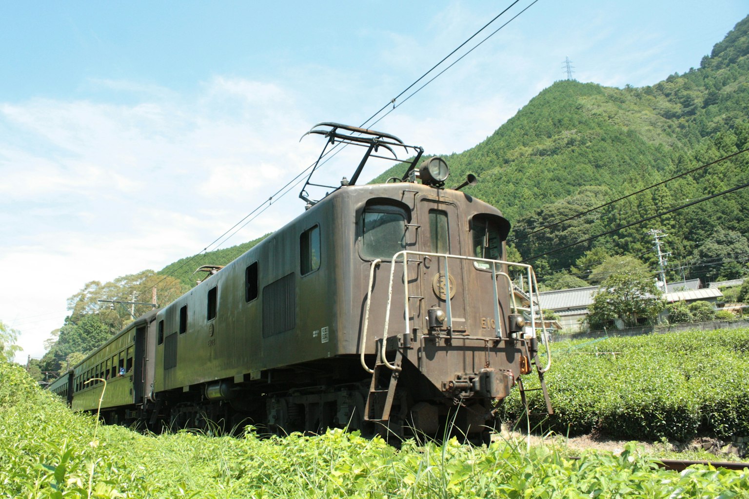 Vieja locomotora de tren parada en un campo verde