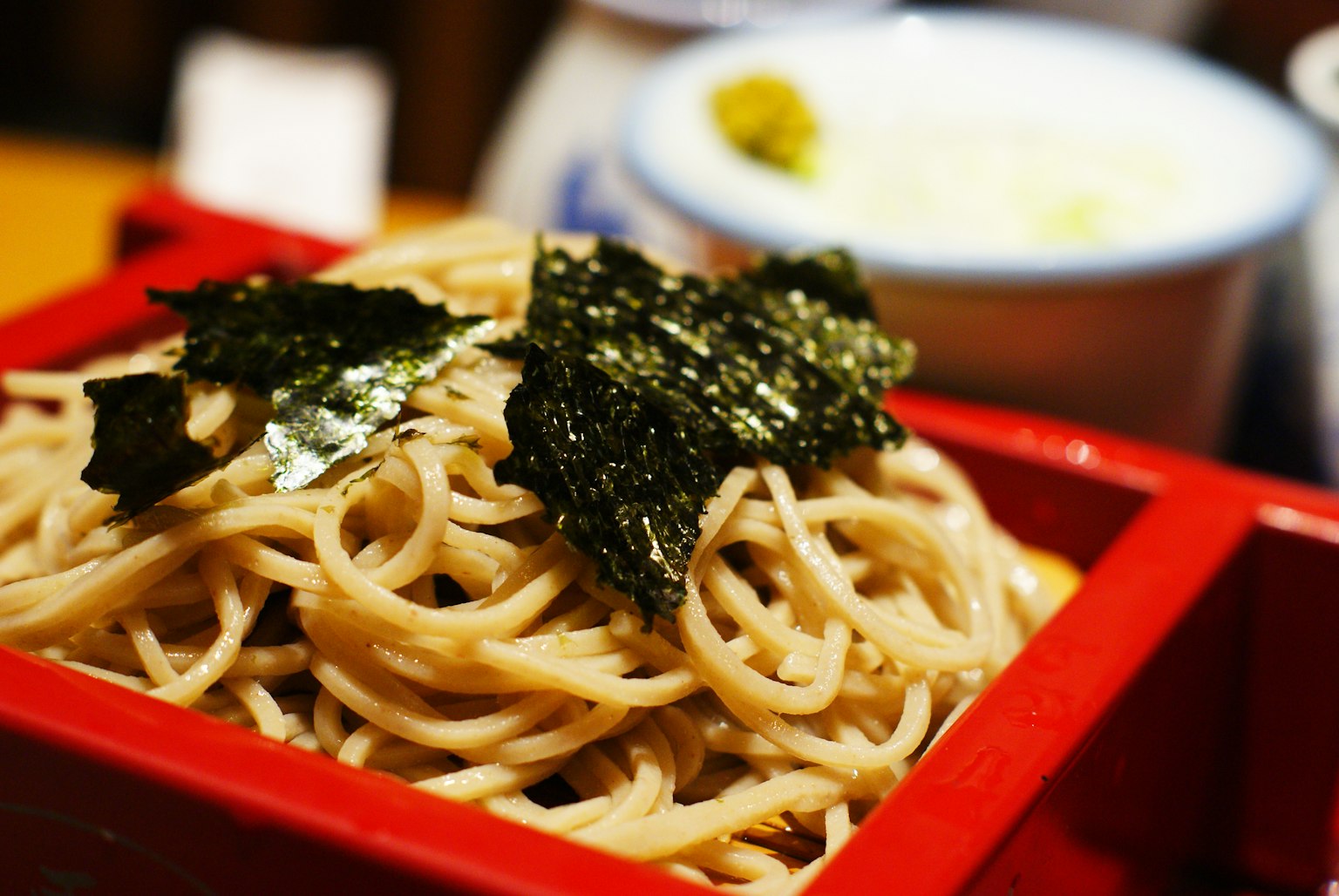 Nouilles soba servies dans un bol rouge garnies d'algues