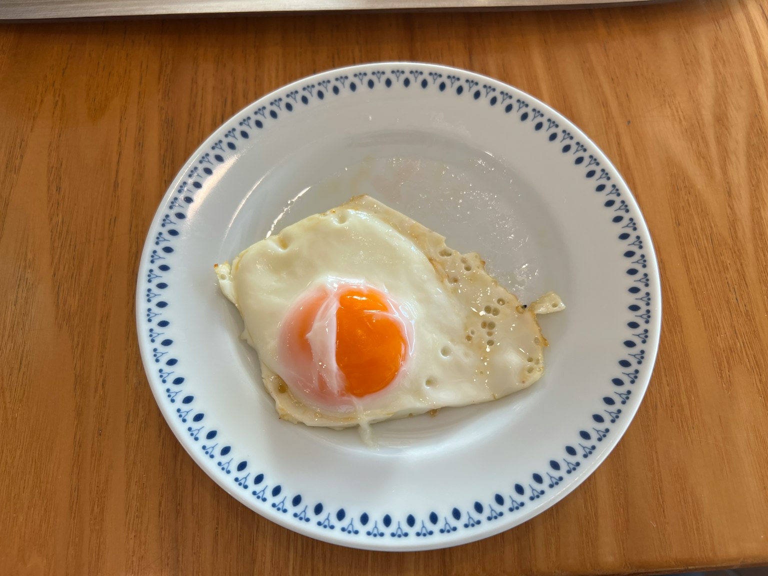 一个装饰边缘的白色盘子上的煎蛋