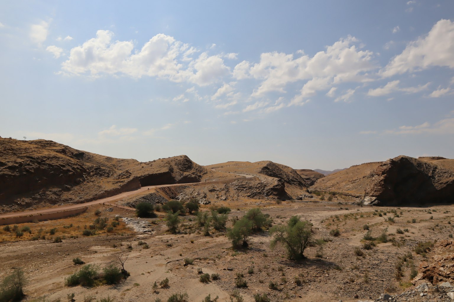 Trockene Landschaft mit Hügeln und blauem Himmel