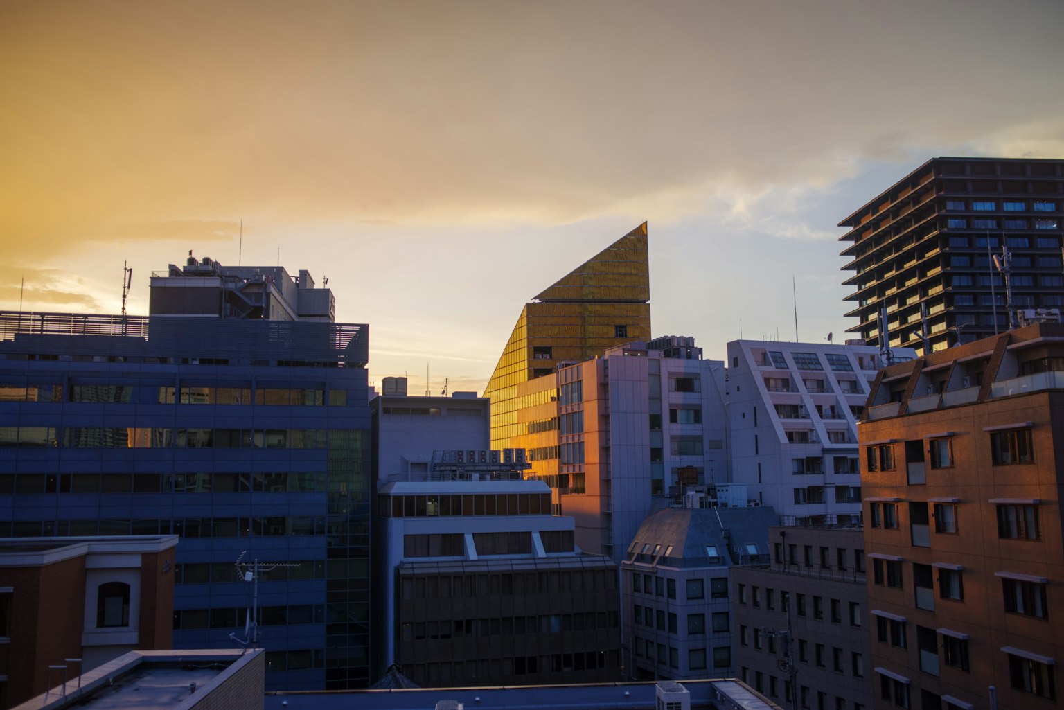 Bâtiments modernes avec des toits uniques sous un ciel de coucher de soleil