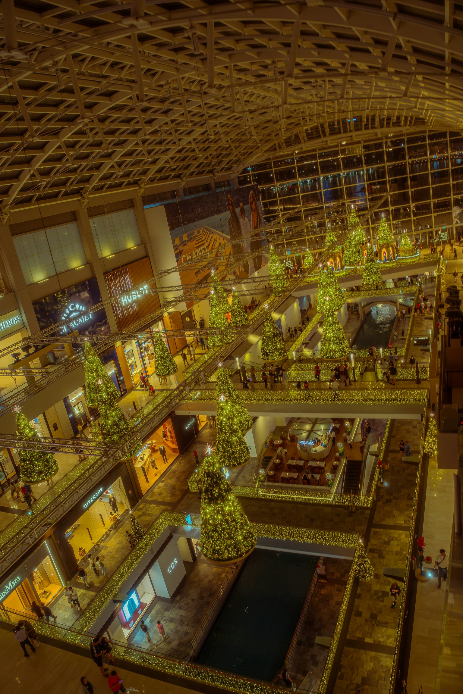 Innenansicht eines Einkaufszentrums mit Weihnachtsbäumen und hoher Decke