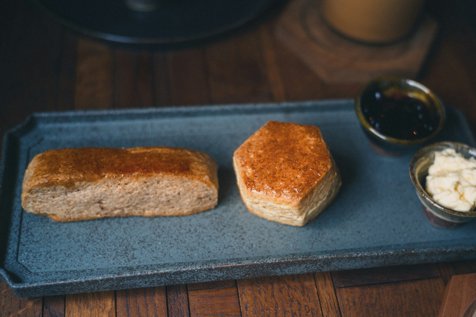 焼きたてのパンとバターの盛り合わせが美しいプレートに盛られている
