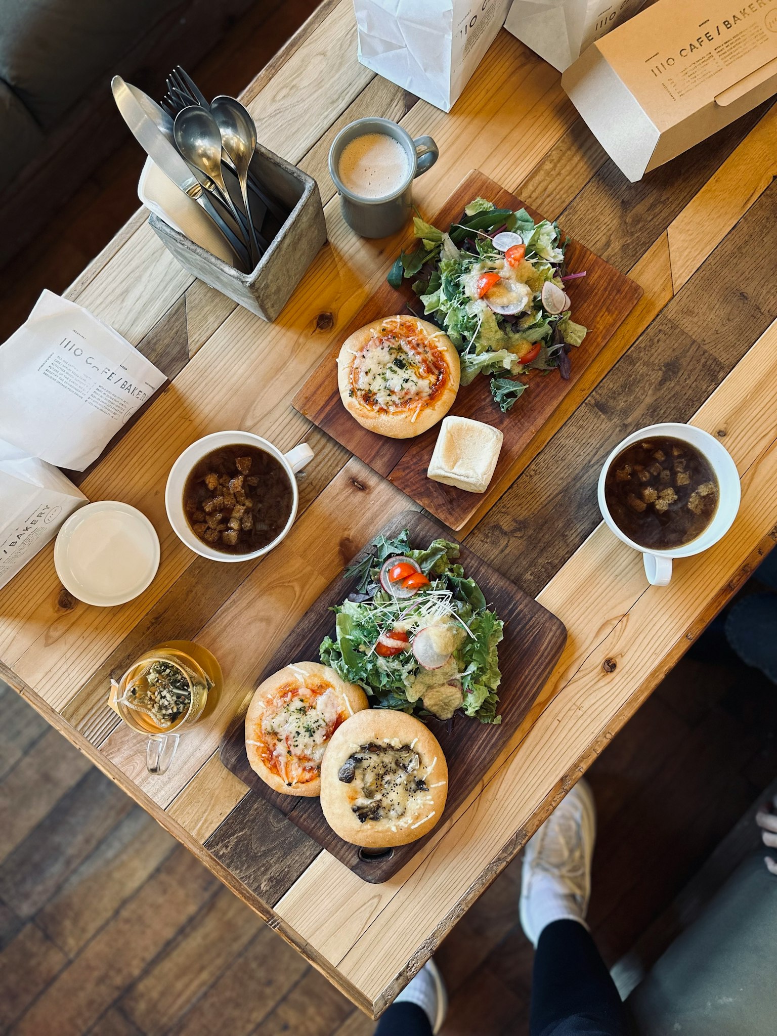 Gerichte und Salat auf einem Tisch mit Kaffee und Getränken in der Nähe