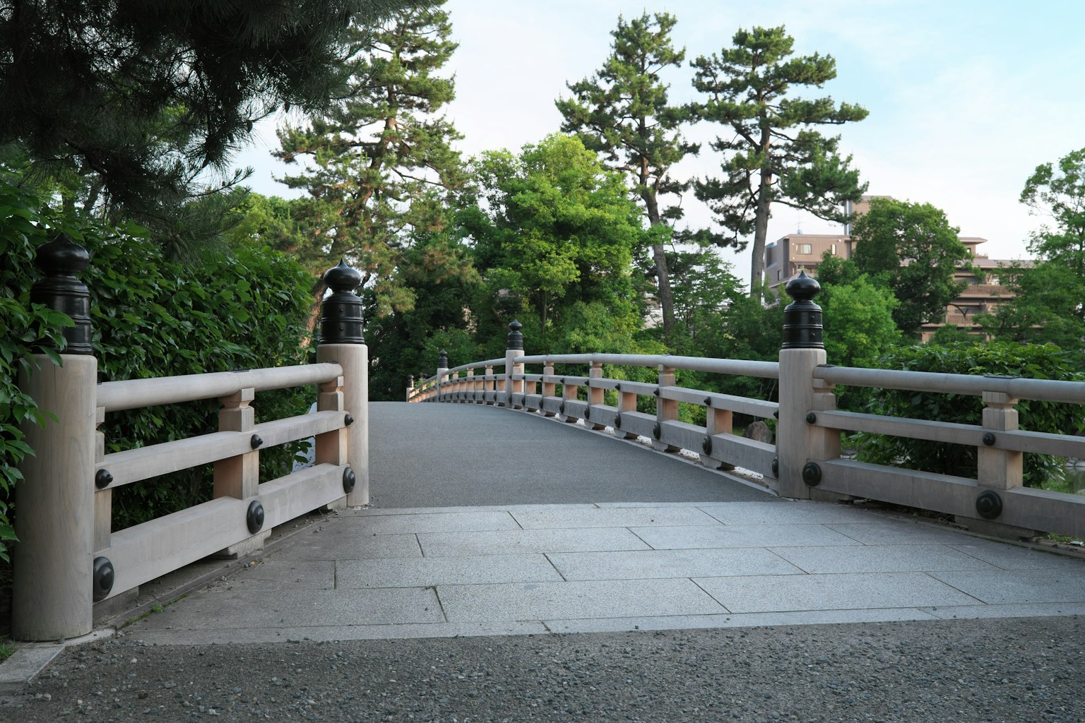 Pont magnifique dans un parc entouré d'arbres verts et d'un chemin en pierre