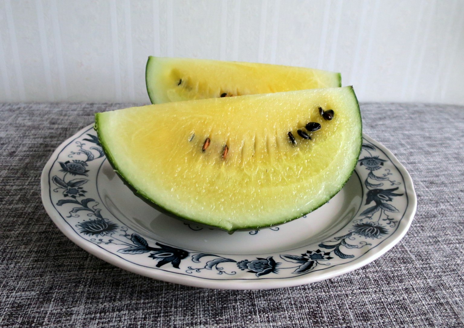 Gelbe Wassermelonenstücke auf einem dekorativen Teller