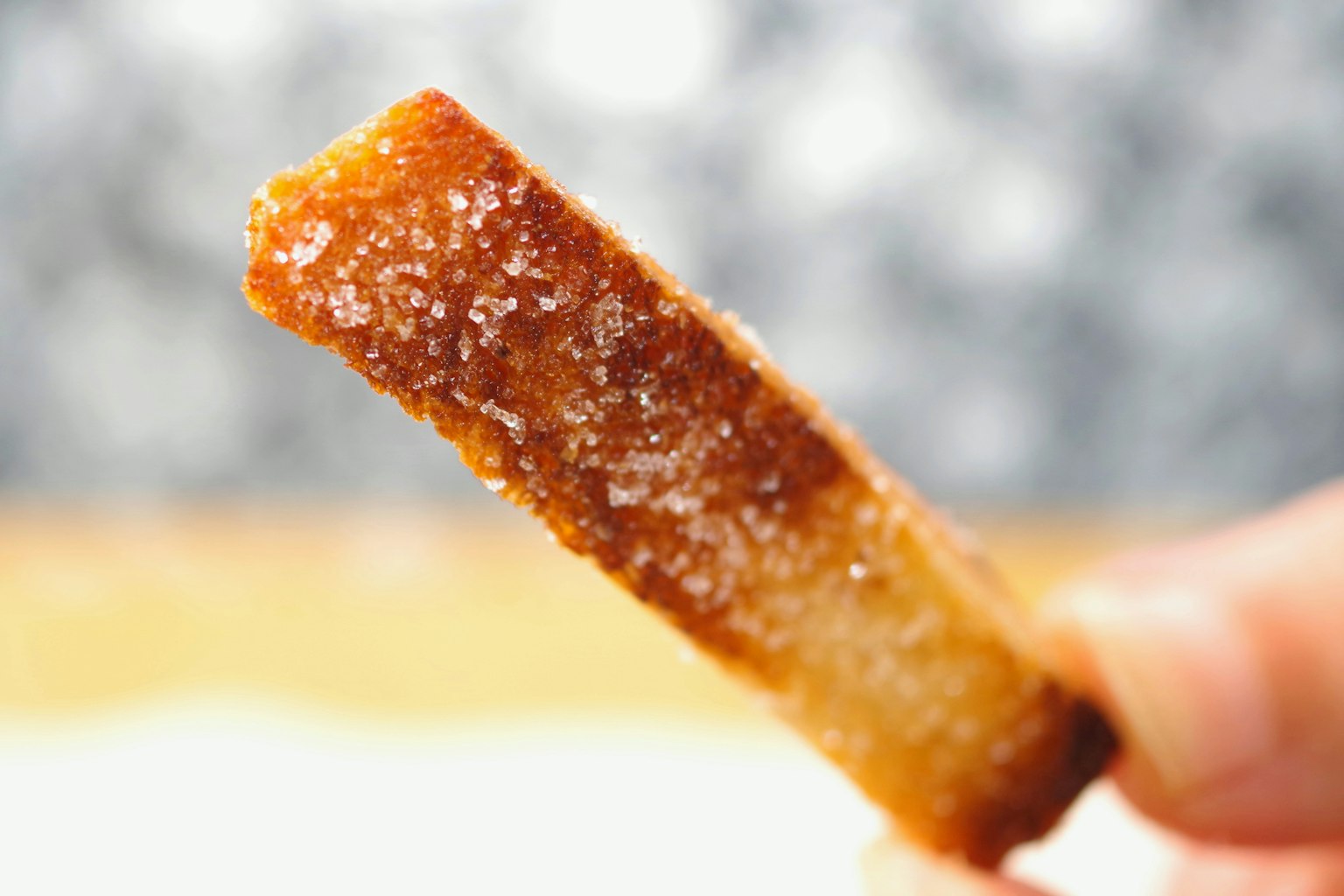 Un postre en forma de bastón cubierto de azúcar caramelizado y con textura crujiente