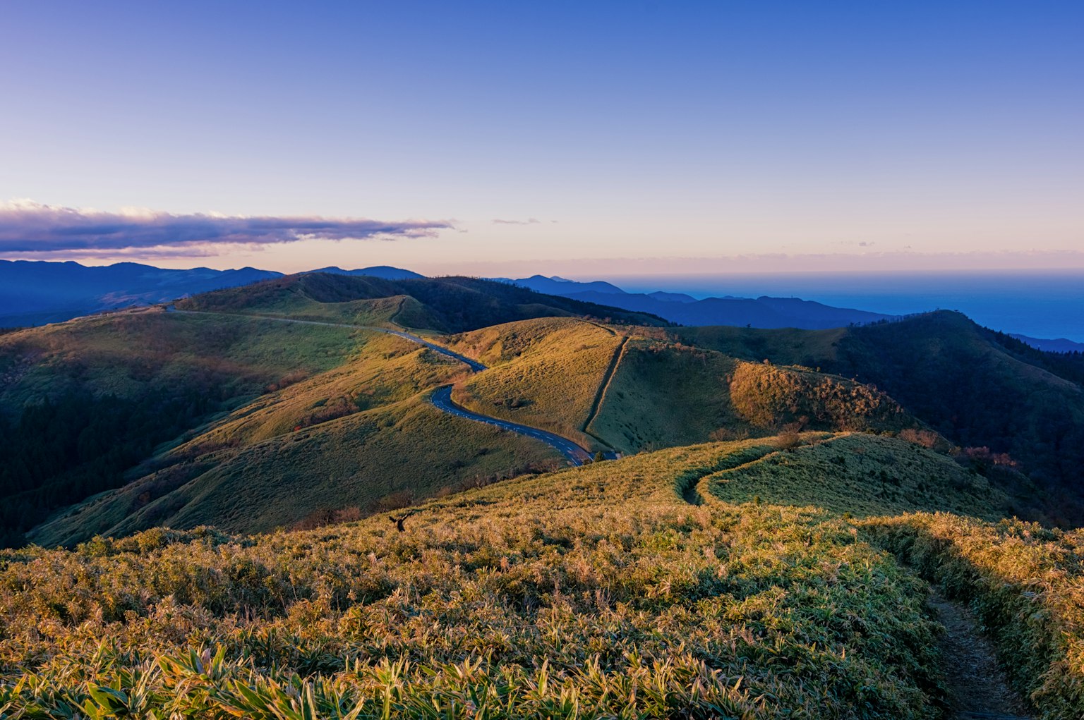 青山绿丘和晴朗蓝天的风景 风景中的蜿蜒小路