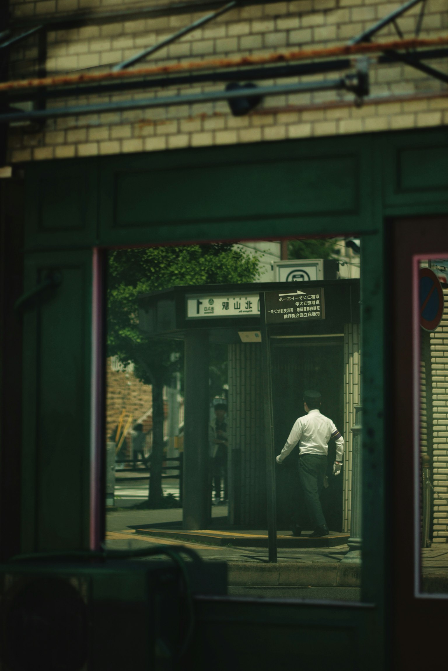 Reflection of a person in a window showing a street scene