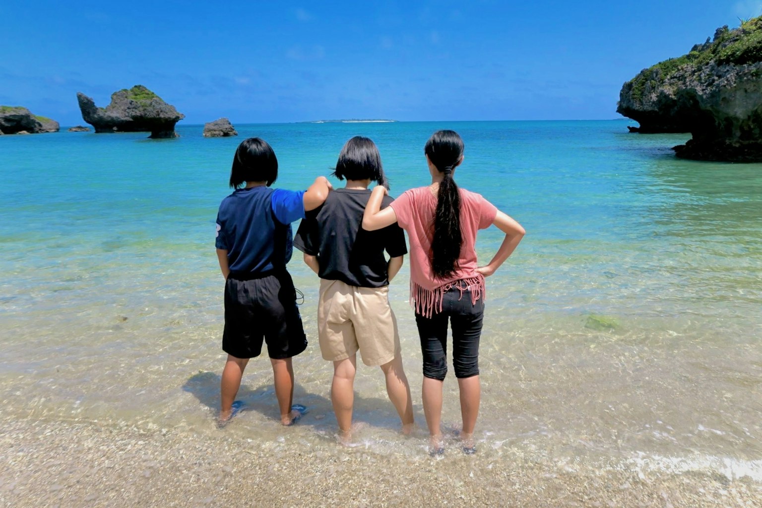 三位朋友在海滩上看海