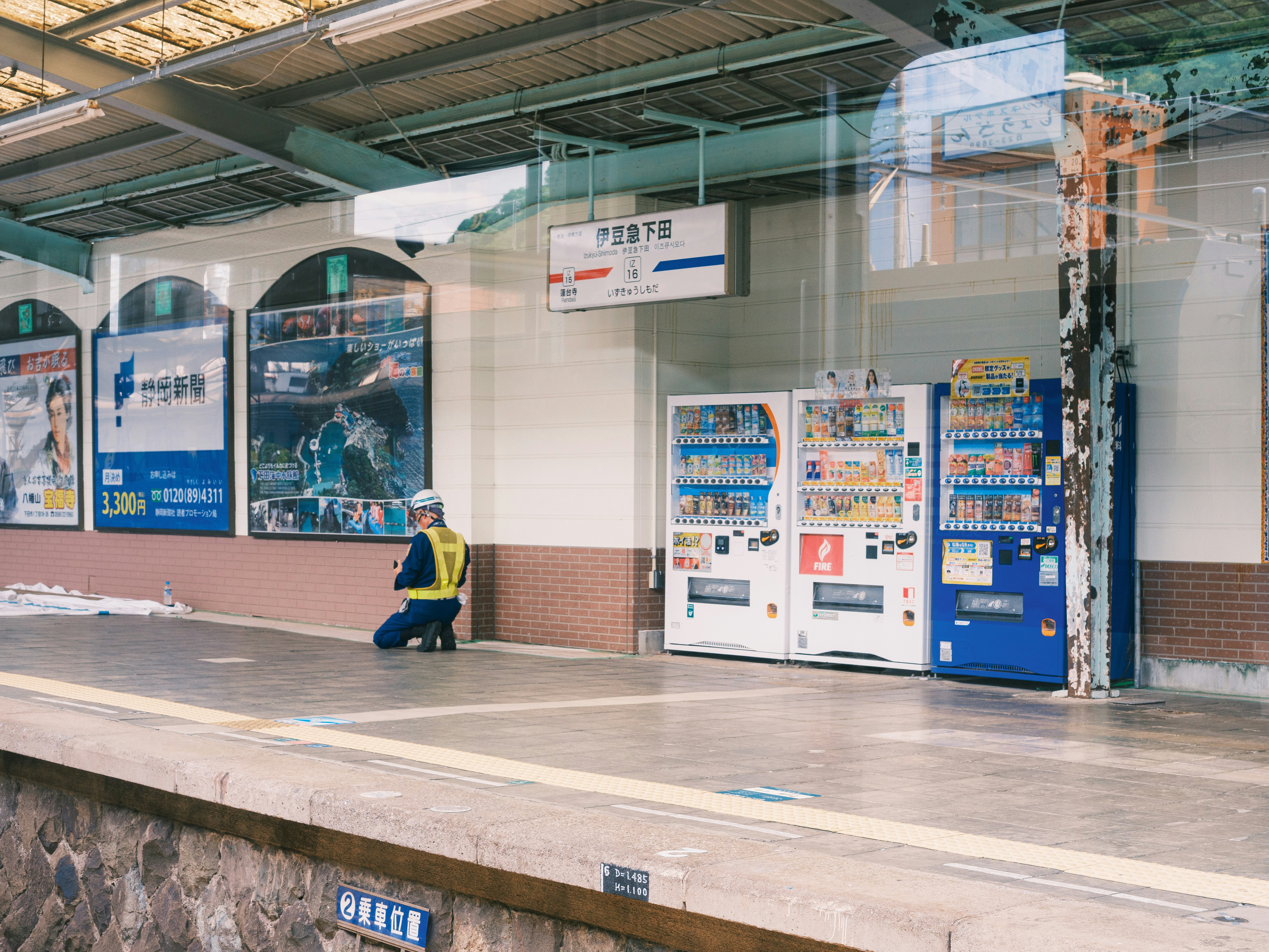 Travailleur sur le quai de la gare à côté des distributeurs automatiques