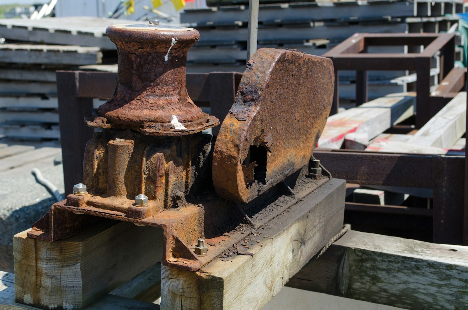 rusted iron machinery part on wooden base