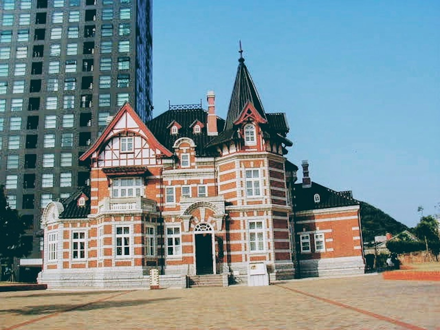 Edificio de ladrillo rojo tradicional en contraste con un rascacielos moderno