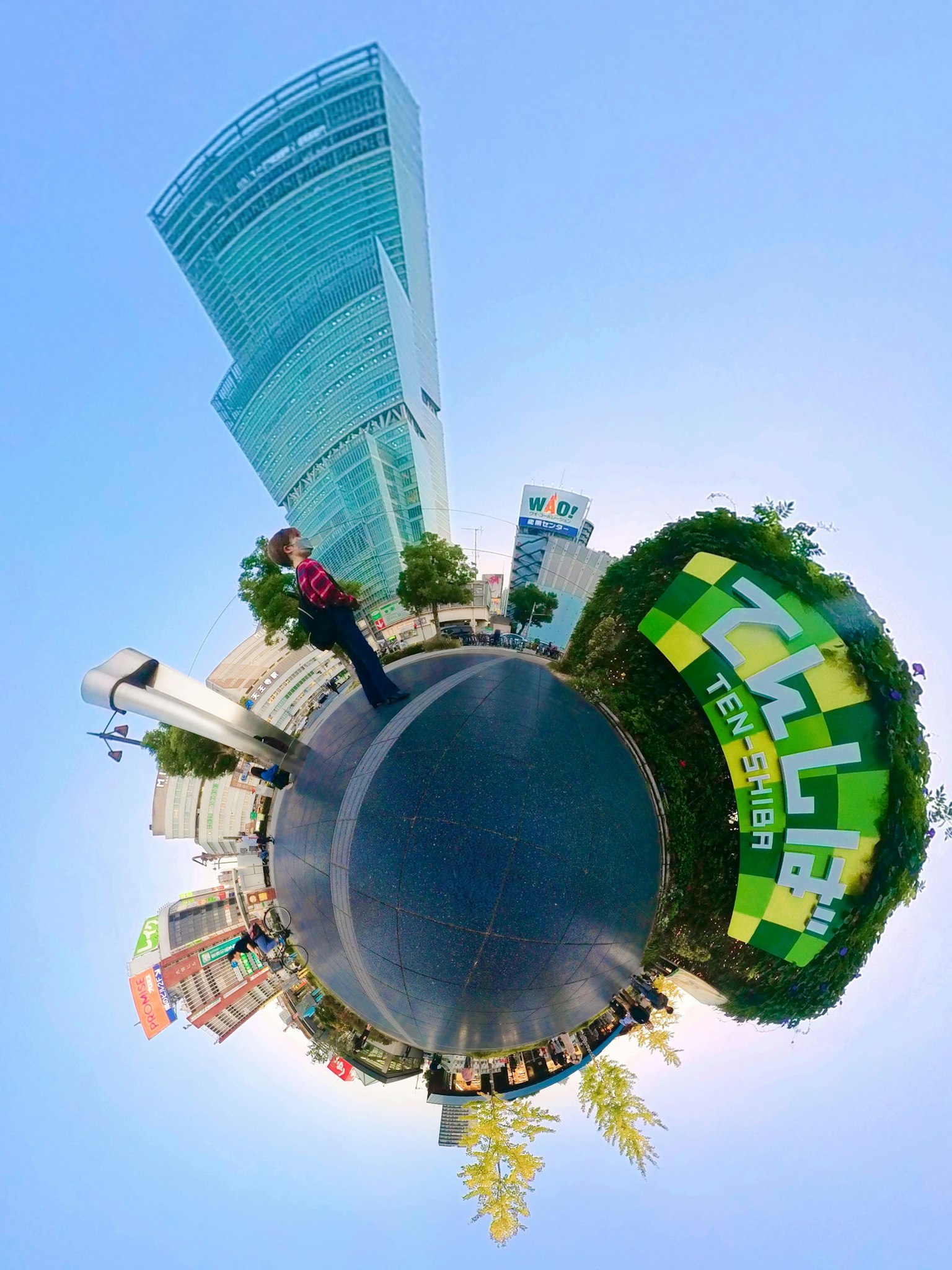 Panoramic view featuring a green park and a skyscraper