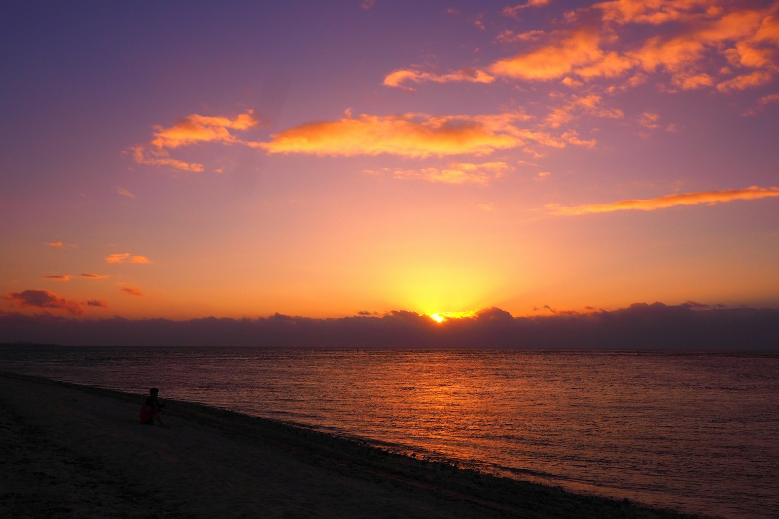 Un bellissimo tramonto sull'oceano con cielo viola e arancione spiaggia tranquilla