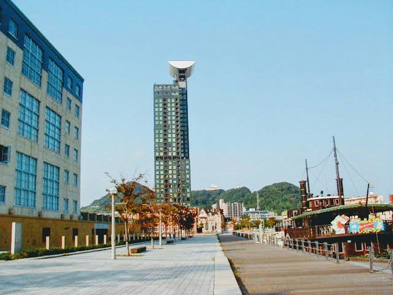 現代建築和歷史船隻沿海岸線