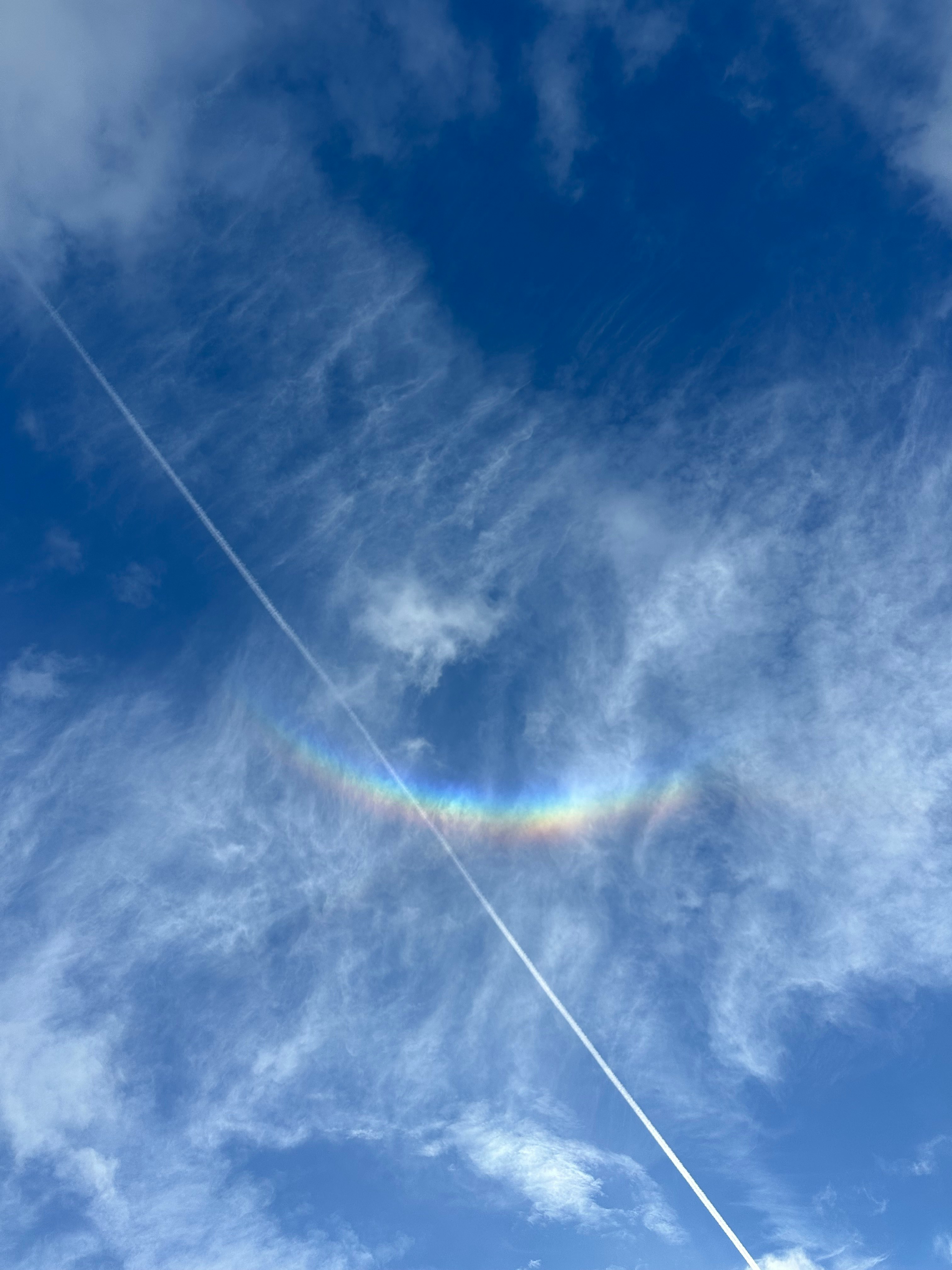 青空に広がる虹のような光と雲