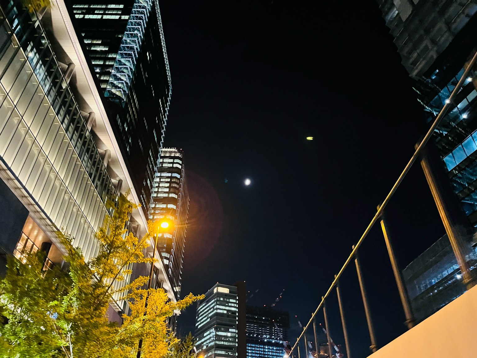 Nächtliche Stadtlandschaft mit sichtbarem Mond und Wolkenkratzern