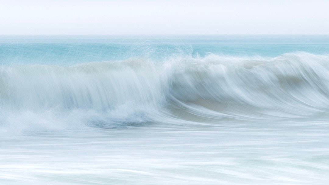 砕ける波の水しぶきと流れる海面