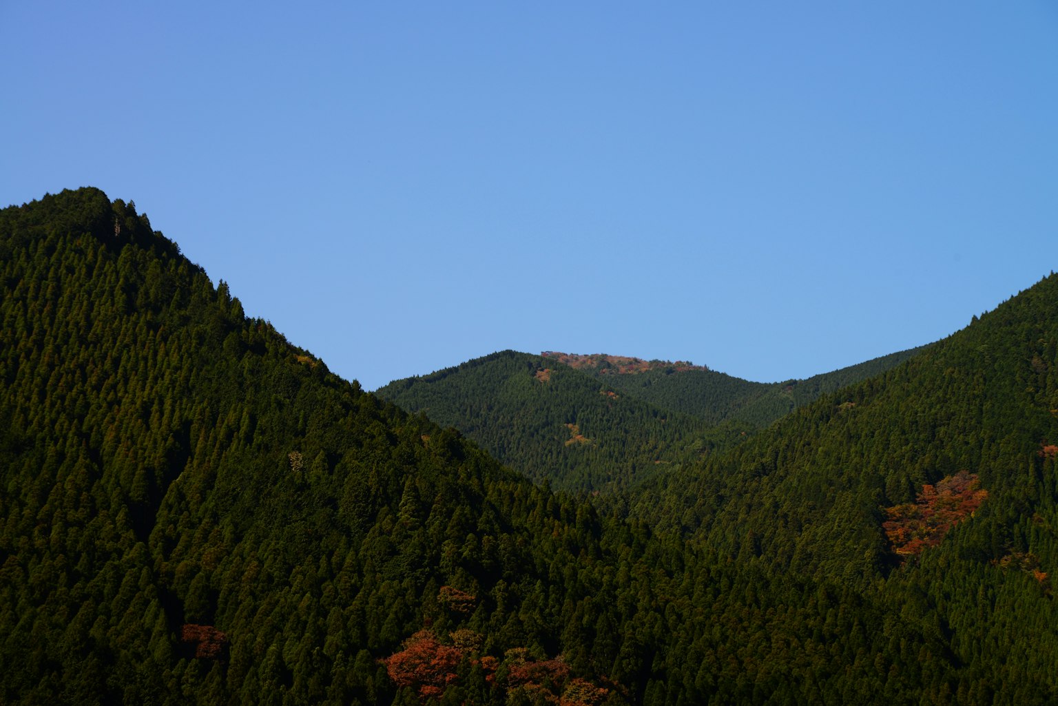 Scenic view of lush green mountains under a clear blue sky