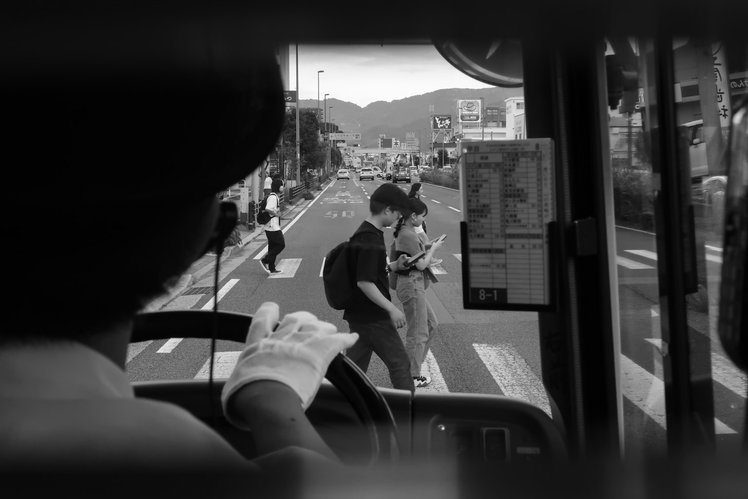 Vue de la perspective d'un conducteur de bus montrant une scène de rue avec un jeune couple traversant