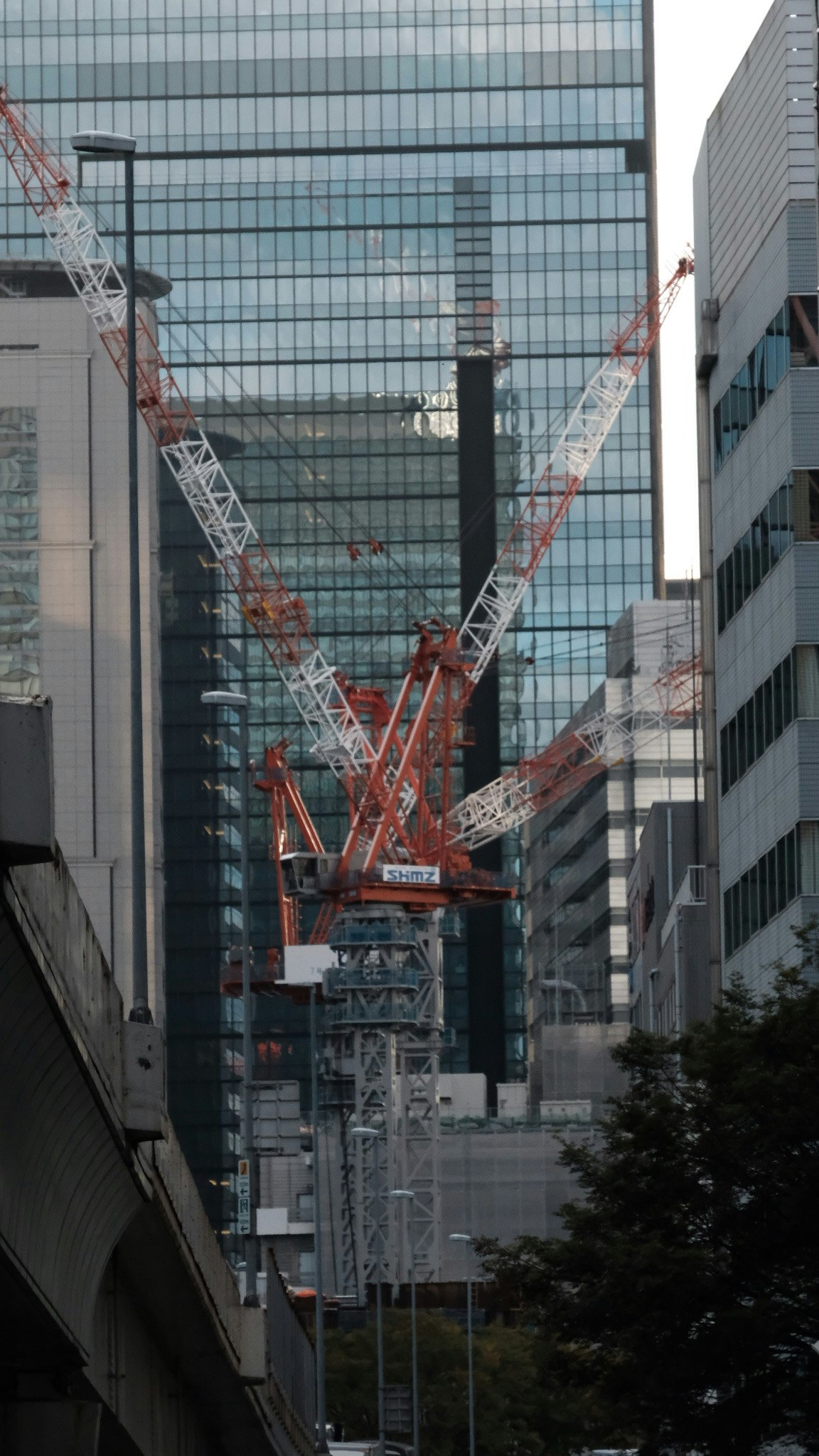 高層ビルに囲まれた工事用クレーンのある都市の建設現場