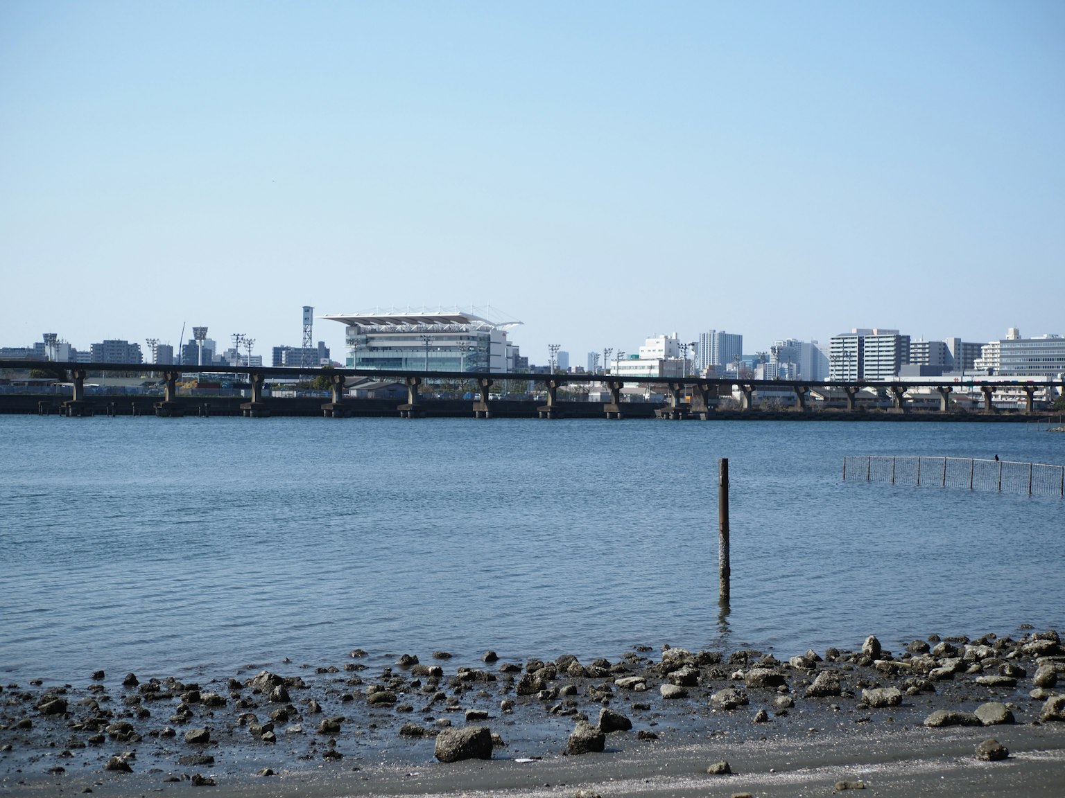 Surface d'eau calme avec un horizon urbain et un pont