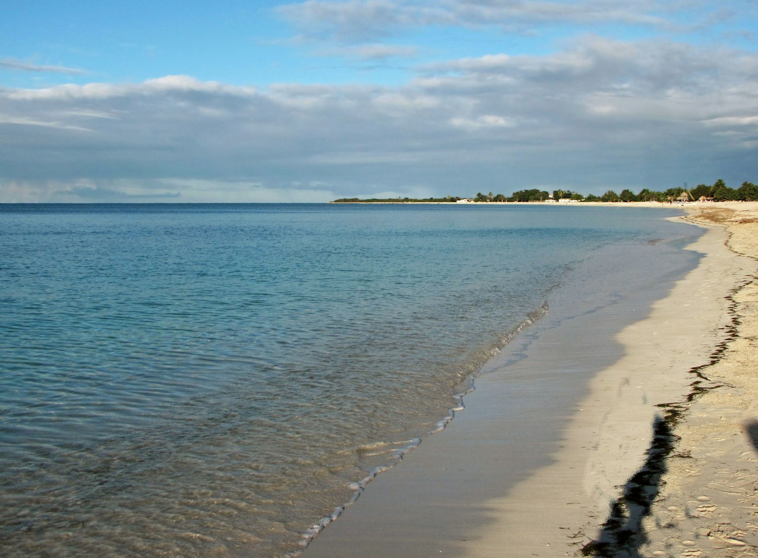 Ruhige See und weißer Sandstrand mit blauem Himmel und Wolken