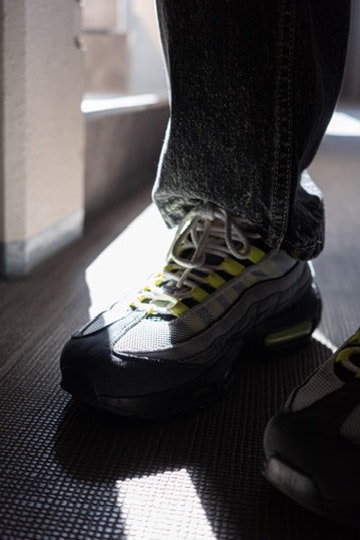 Füße beim Anziehen von Sneakers in einem sonnigen Flur