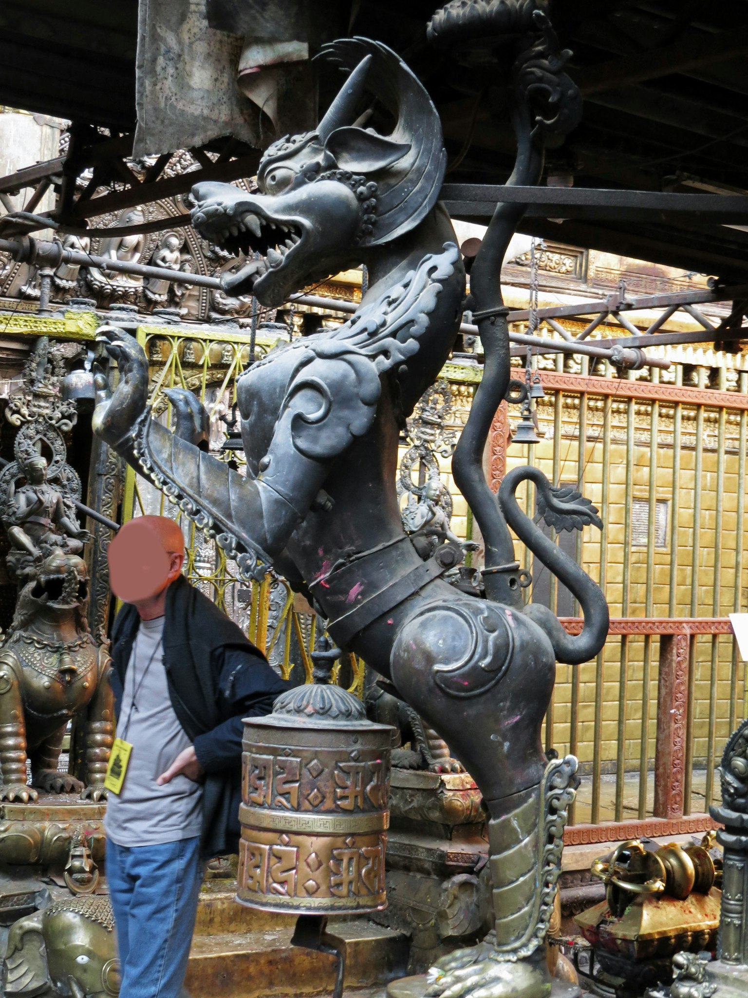 Sculpture métallique unique d'une bête en arrière-plan avec une personne s'appuyant contre elle