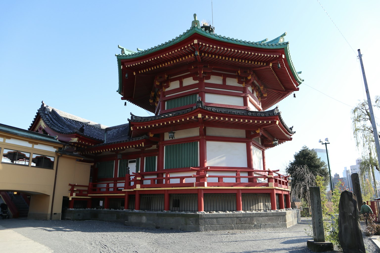 Ein japanisches Tempelgebäude mit rotem Dach steht unter blauem Himmel