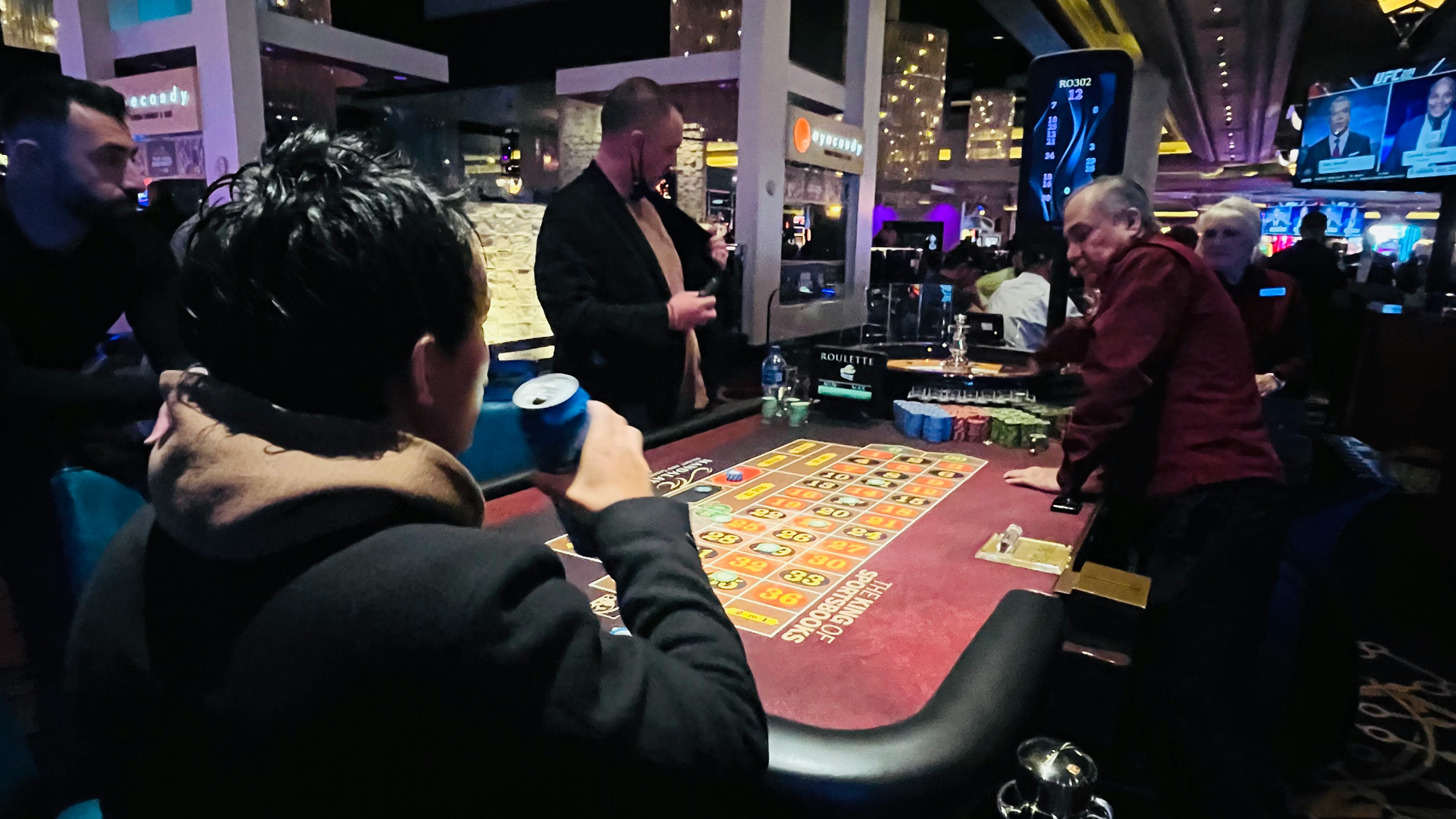 Tavolo da poker in un casinò con croupier e giocatori