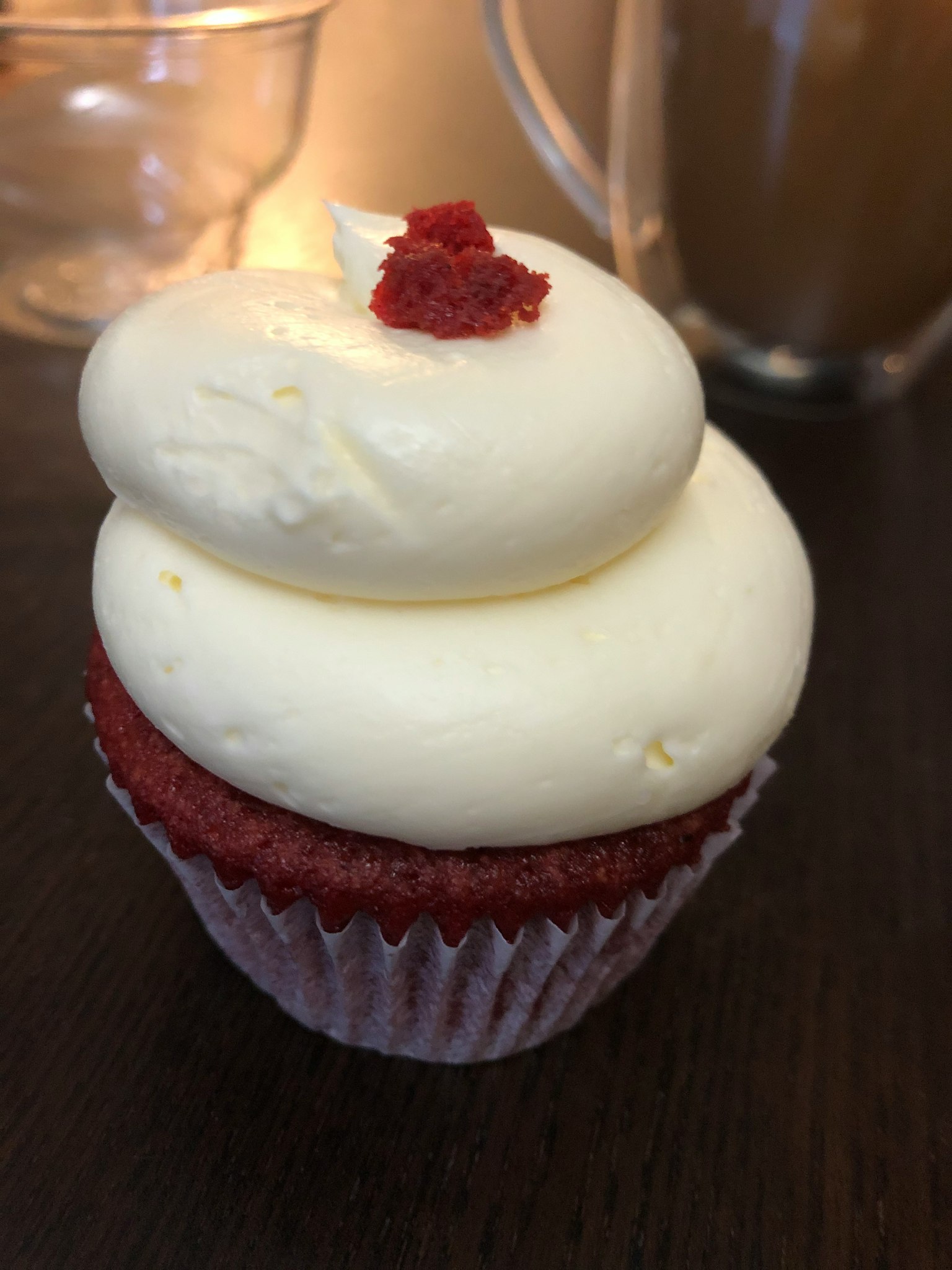 Cupcake al velluto rosso guarnito con glassa al formaggio cremoso e briciole rosse