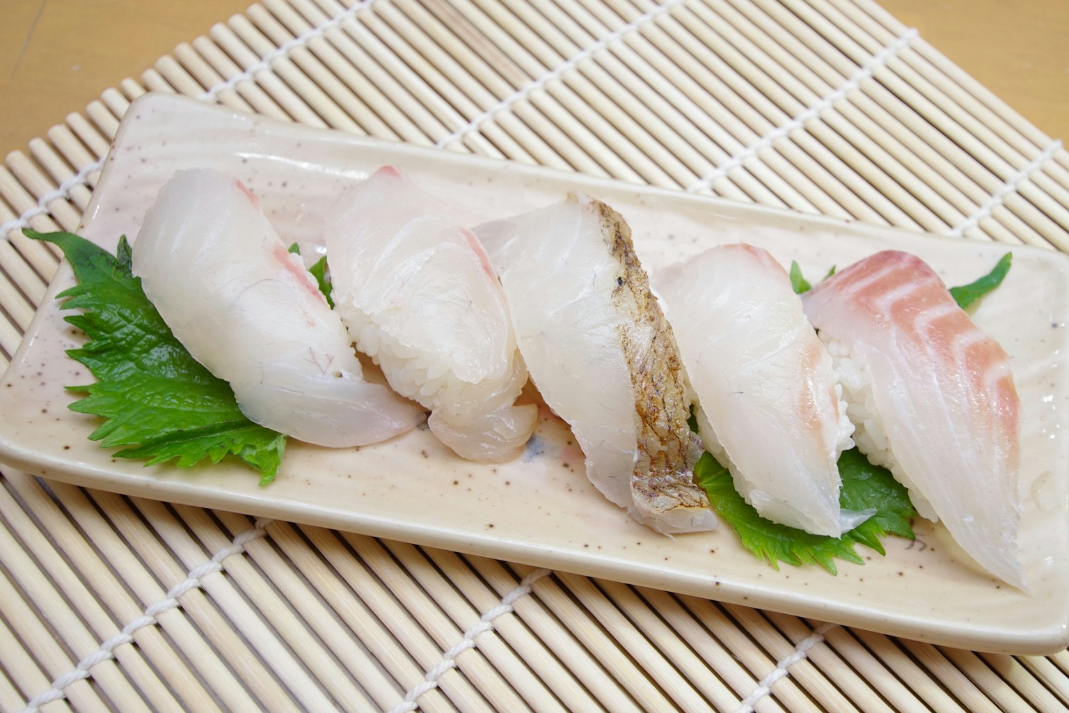 신선한 생선 초밥이 접시에 배열되어 있다