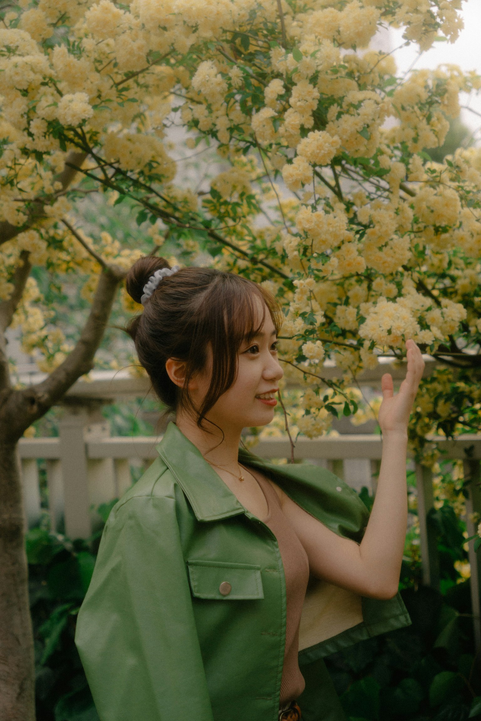 在黄色花树前微笑的女性