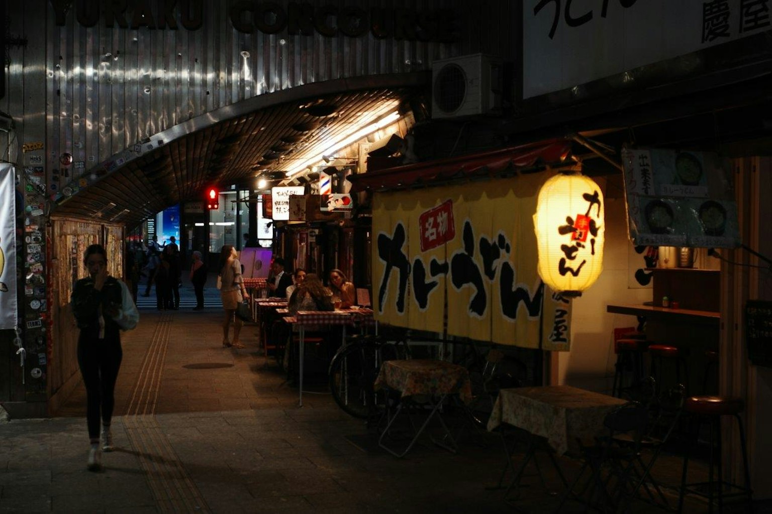 조명이 비친 식당 간판과 외로운 보행자가 있는 거리 풍경