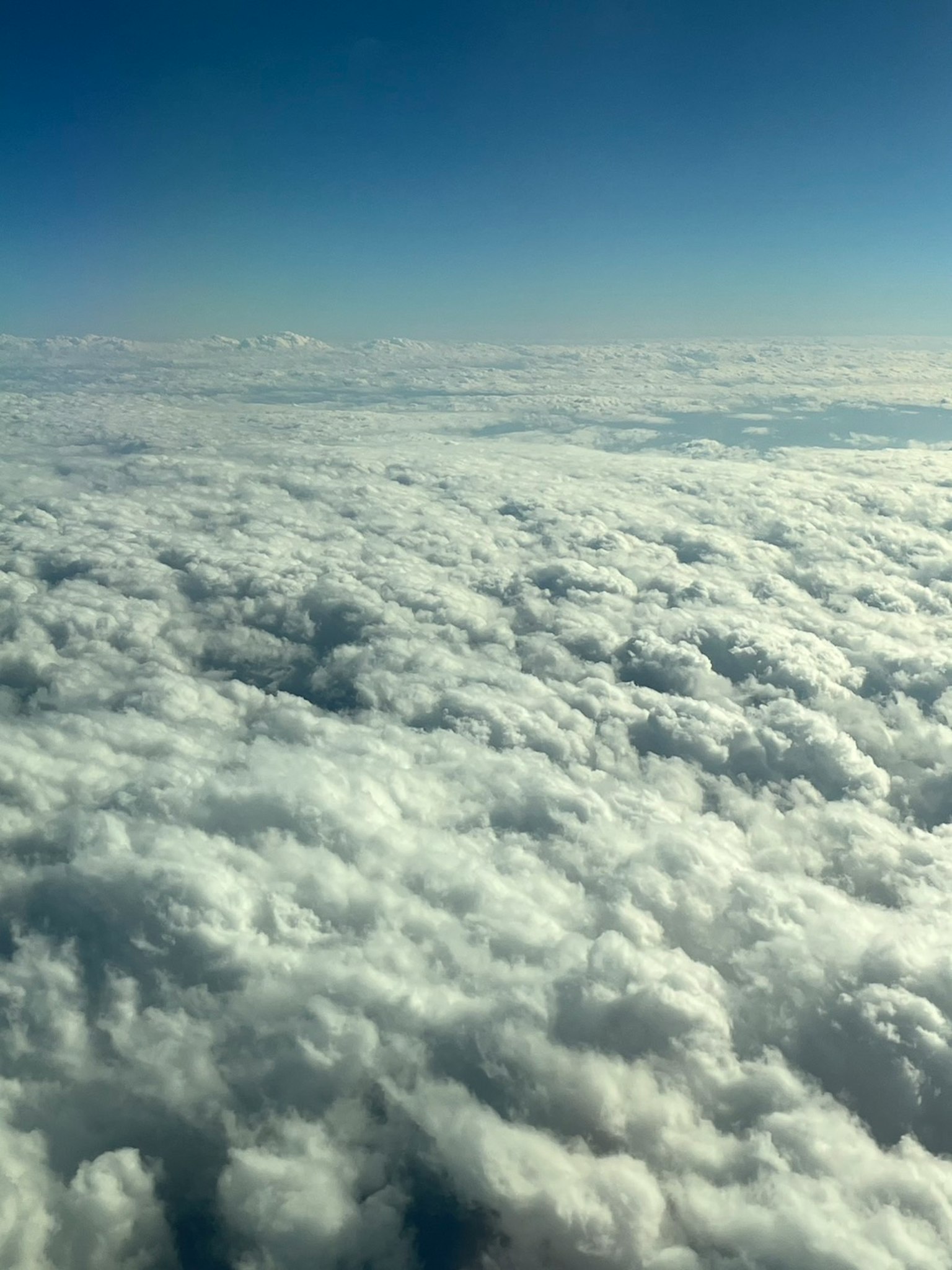 Pemandangan udara yang menangkap lautan awan di bawah langit biru