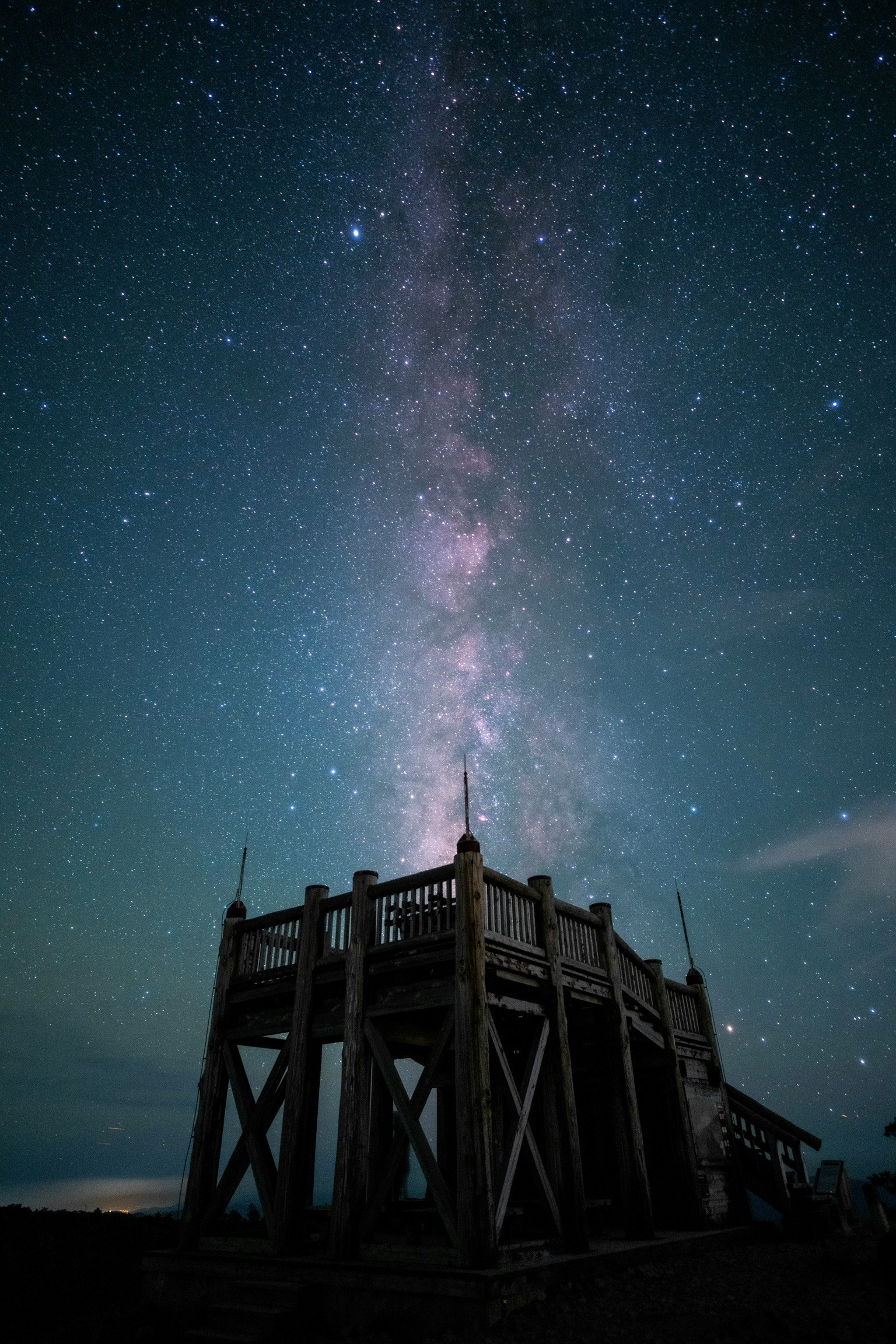 天に昇る櫓のシルエットと満天の星空