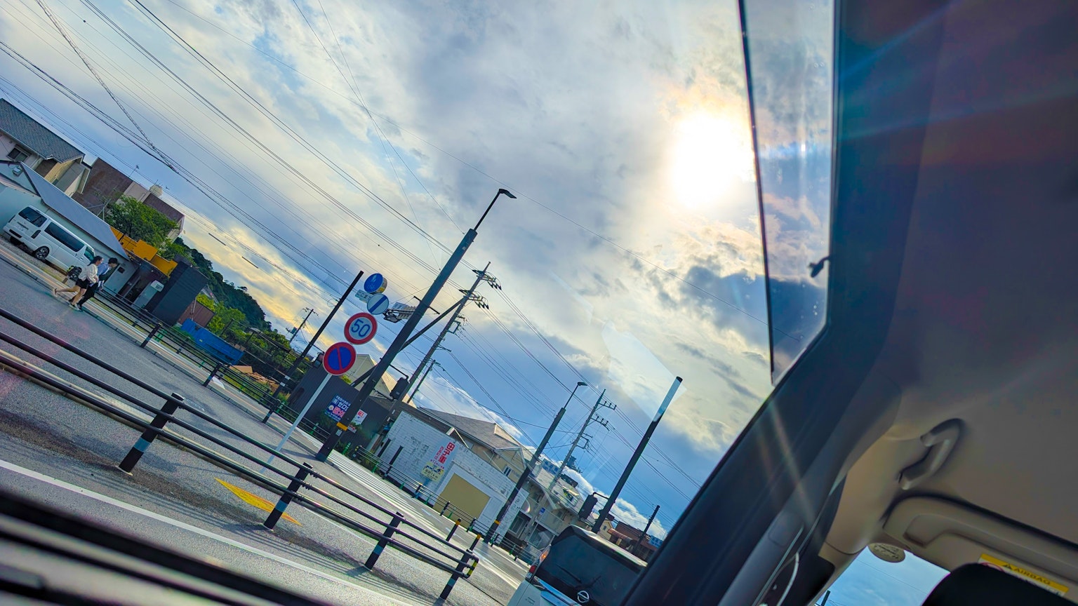 Vue depuis une fenêtre de voiture montrant le ciel bleu et les nuages avec la lumière du soleil
