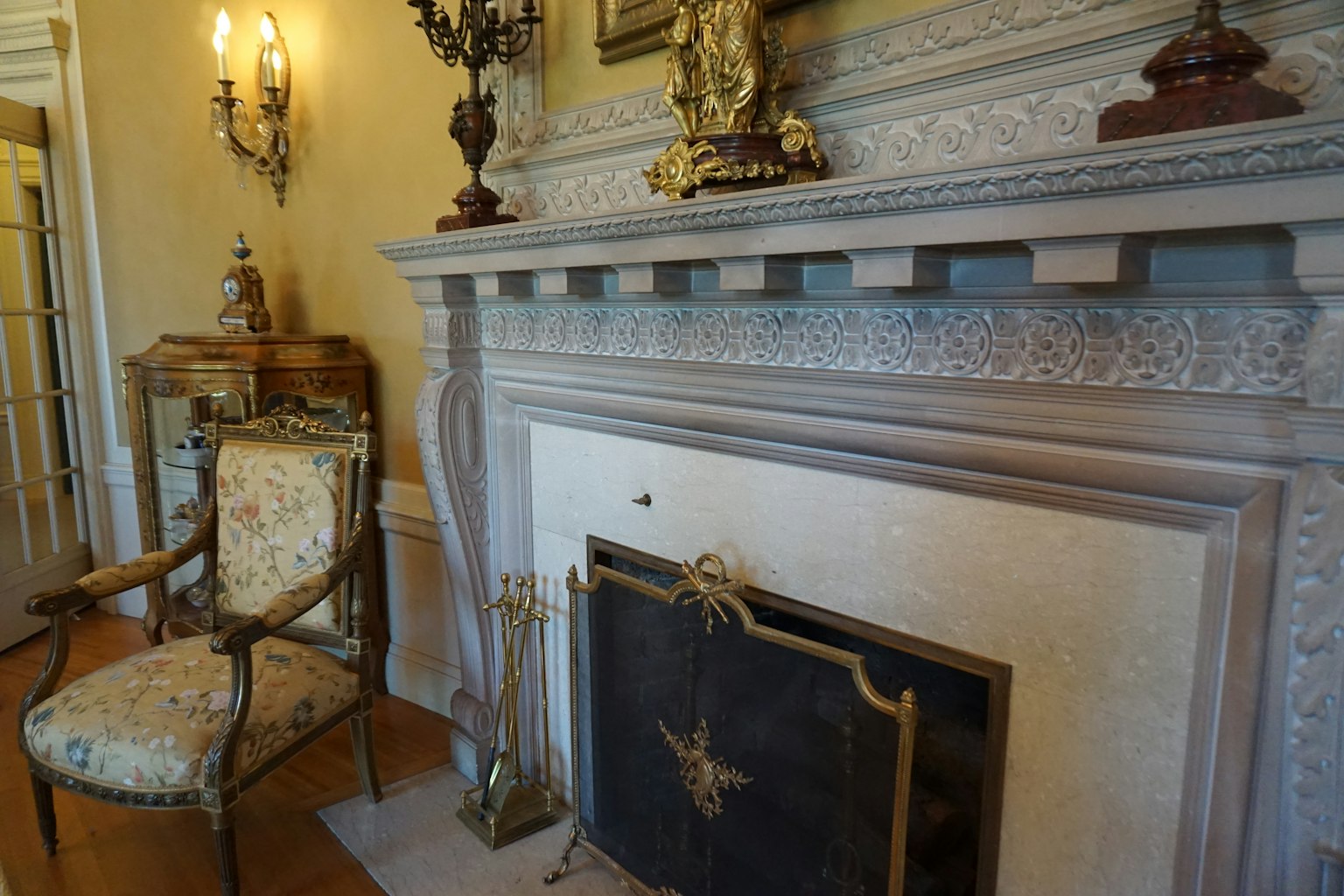 Interno elegante di una stanza con una sedia decorativa e un camino ornato
