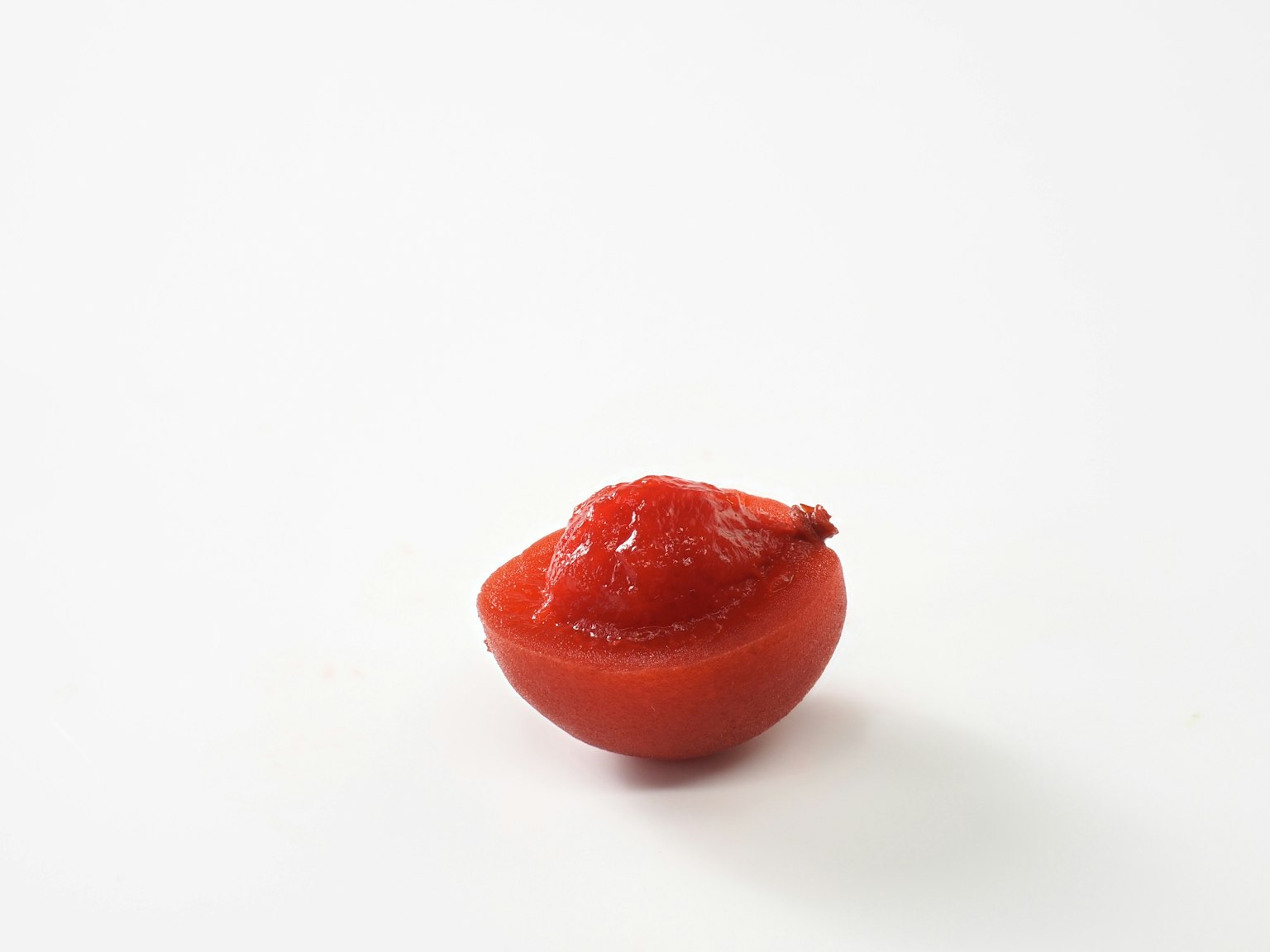 Half of a red tomato topped with ketchup