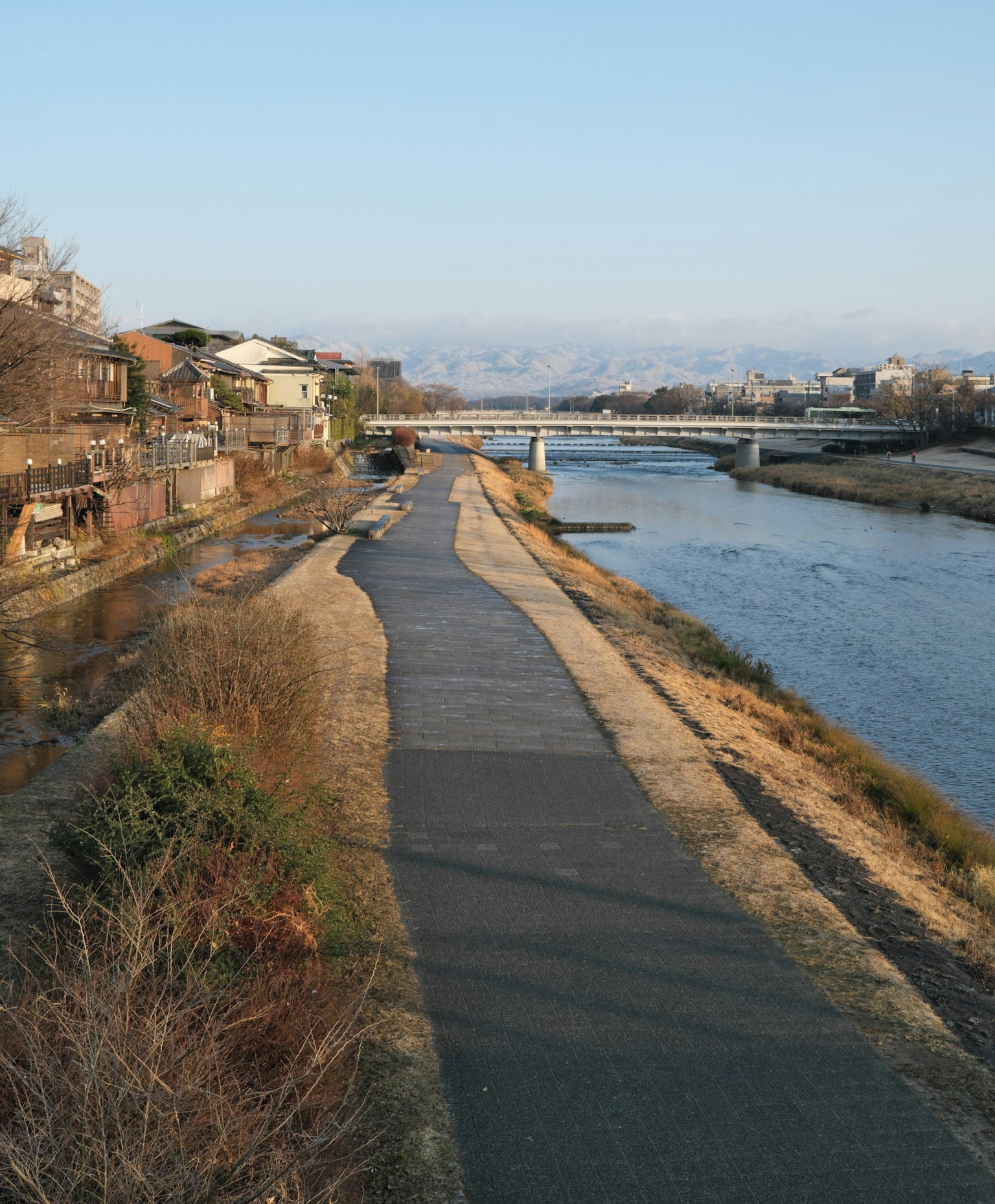 Scenic riverside path with residential buildings