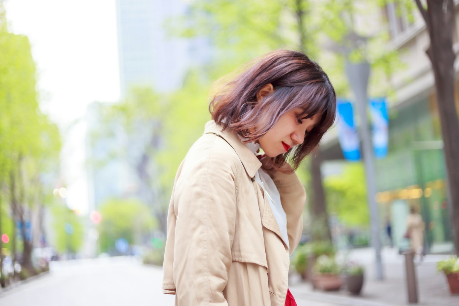城市環境中穿著柔和色彩外套的女性側臉圖像