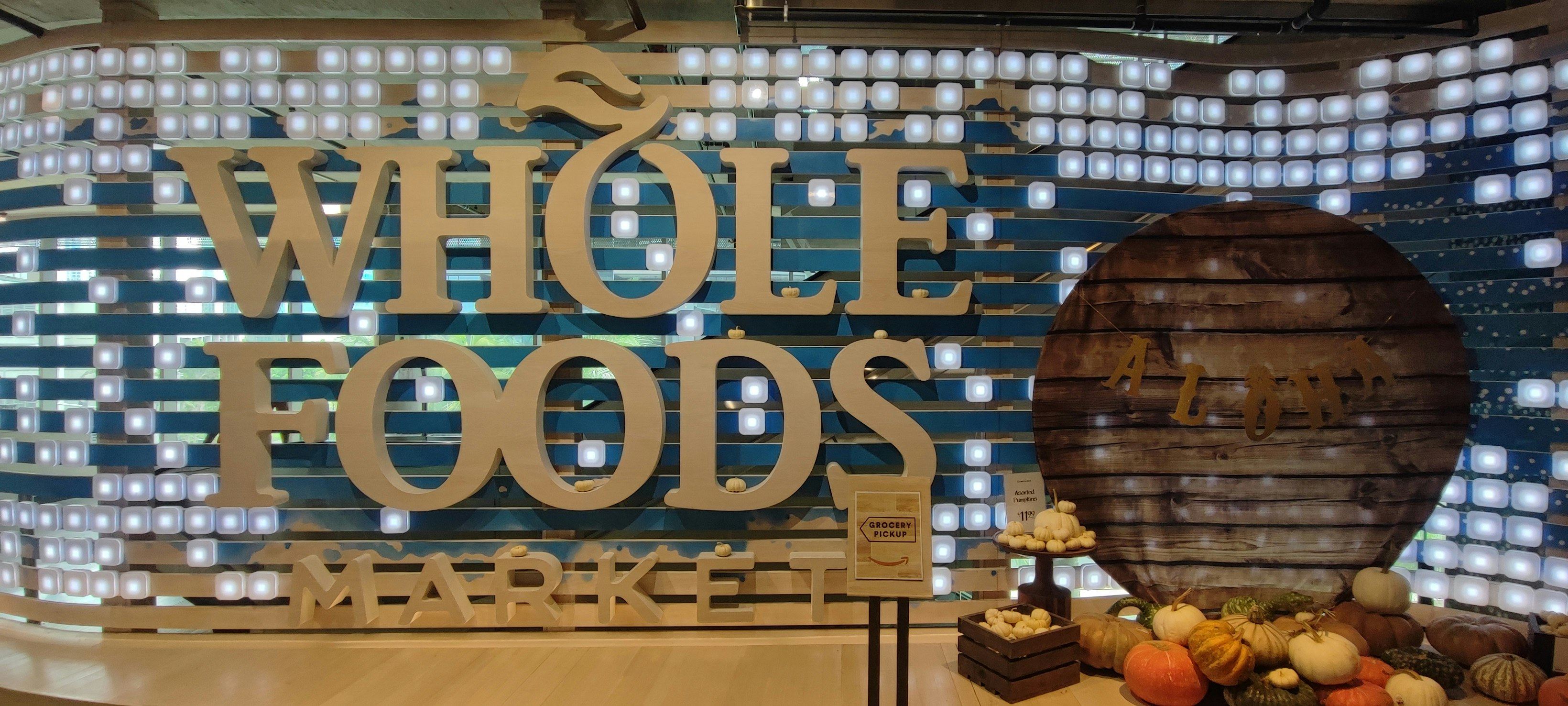 Indoor display with a “WHOLE FOODS” logo and wooden barrel decor