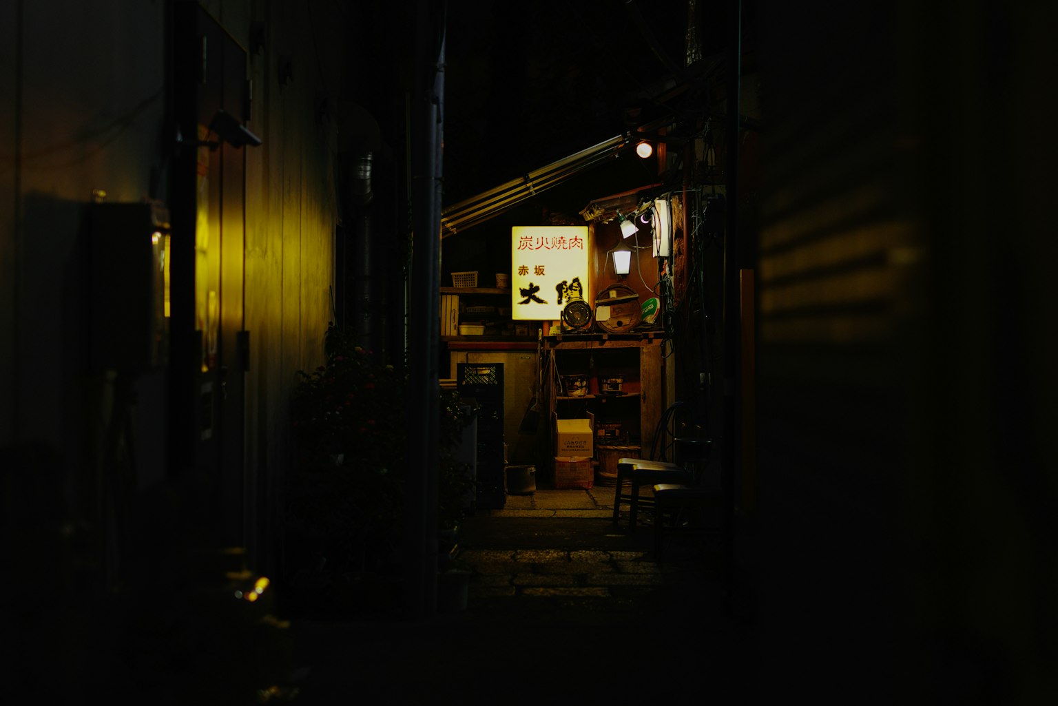 Narrow alleyway with warm light from a food stall
