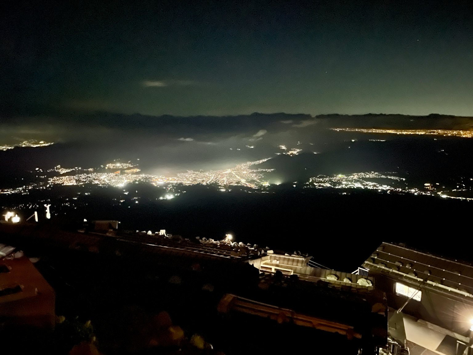 Night view from a mountain overlook Bright city lights and starry sky