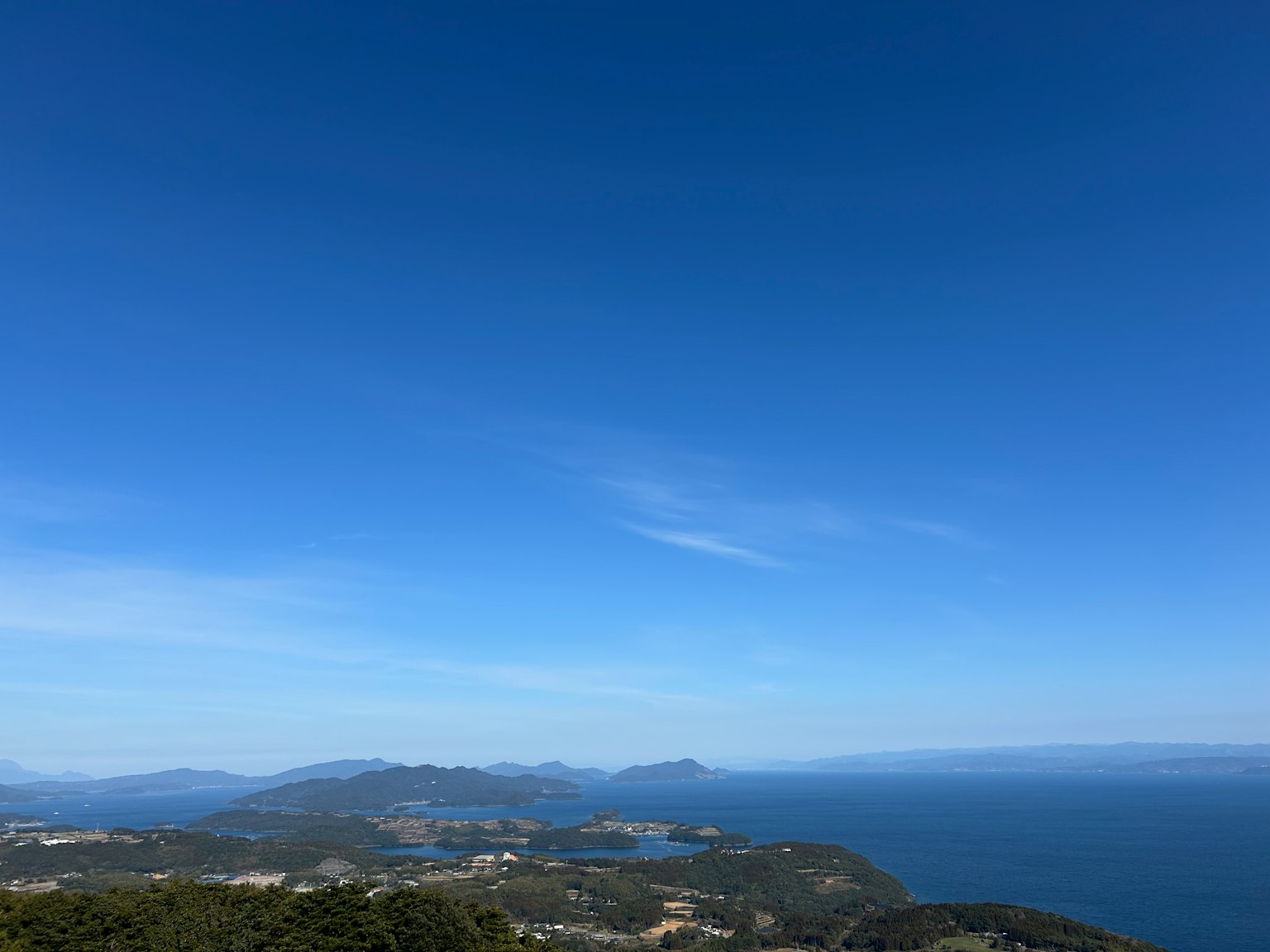 Panoramic view of blue sky and ocean with mountains and coastline