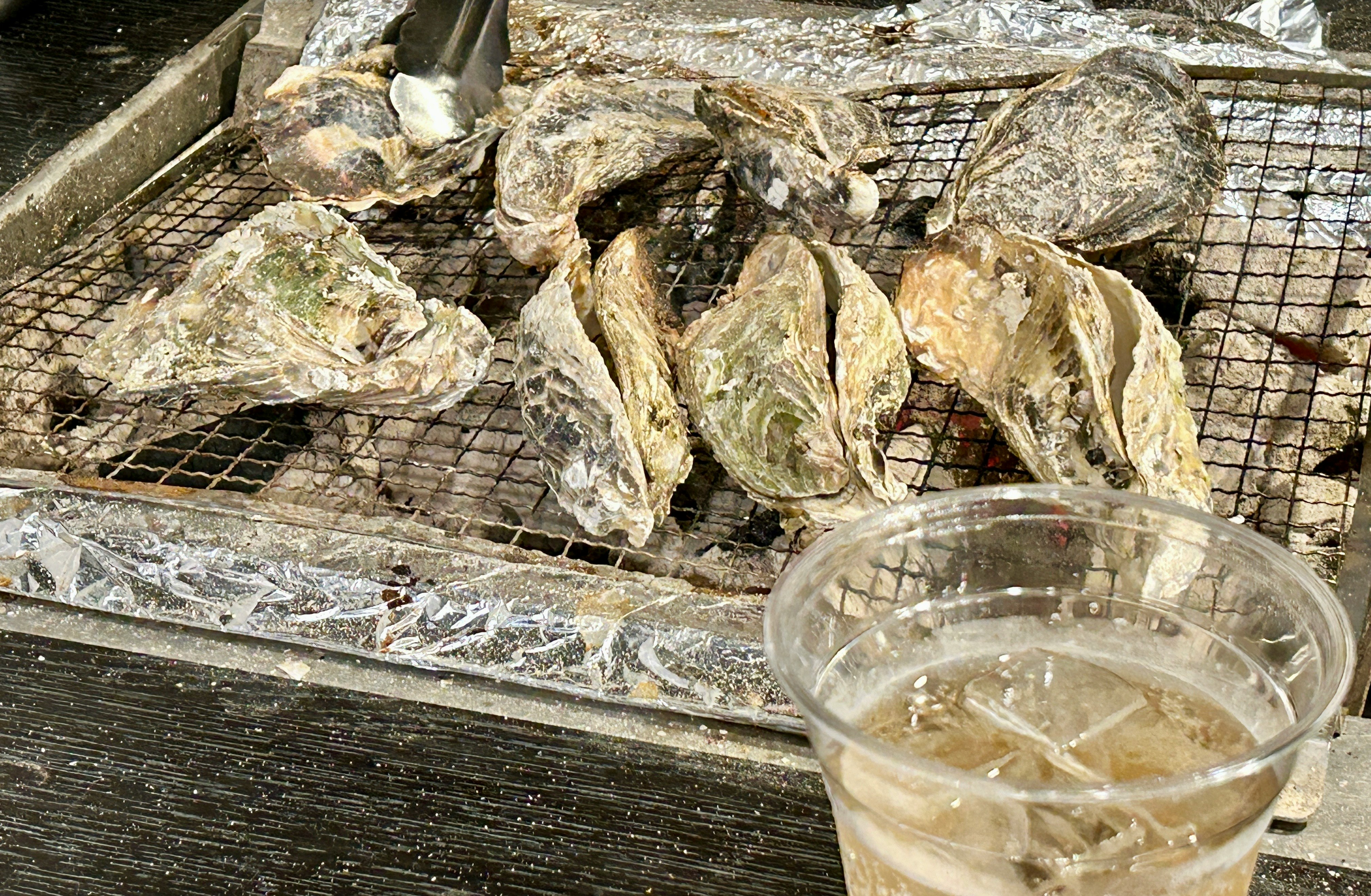 铁丝网上的烤生蚝与海鲜烧烤餐桌